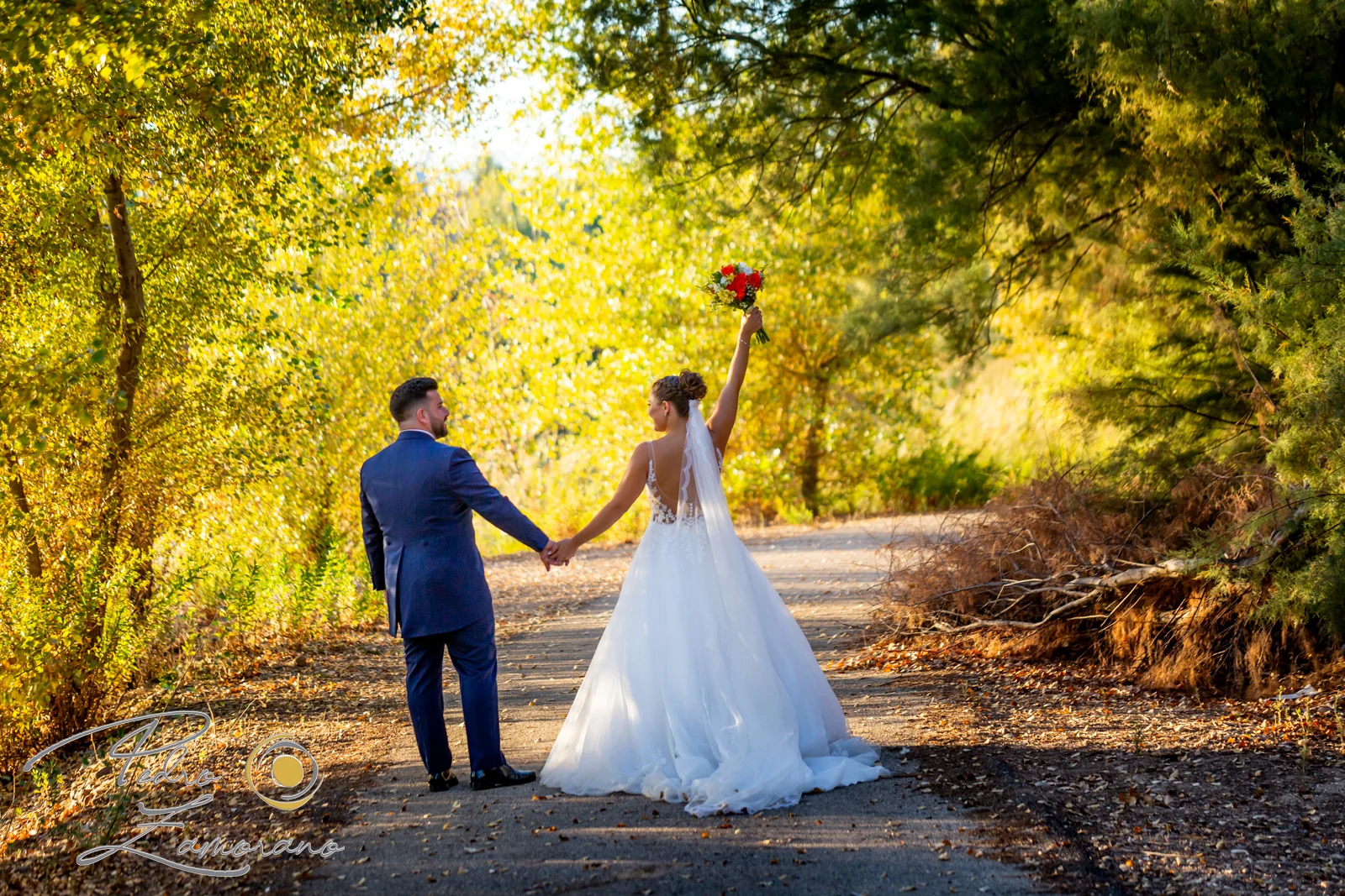Novios de la mano en un camino de la finca en una boda en Complejo La Cigüeña
