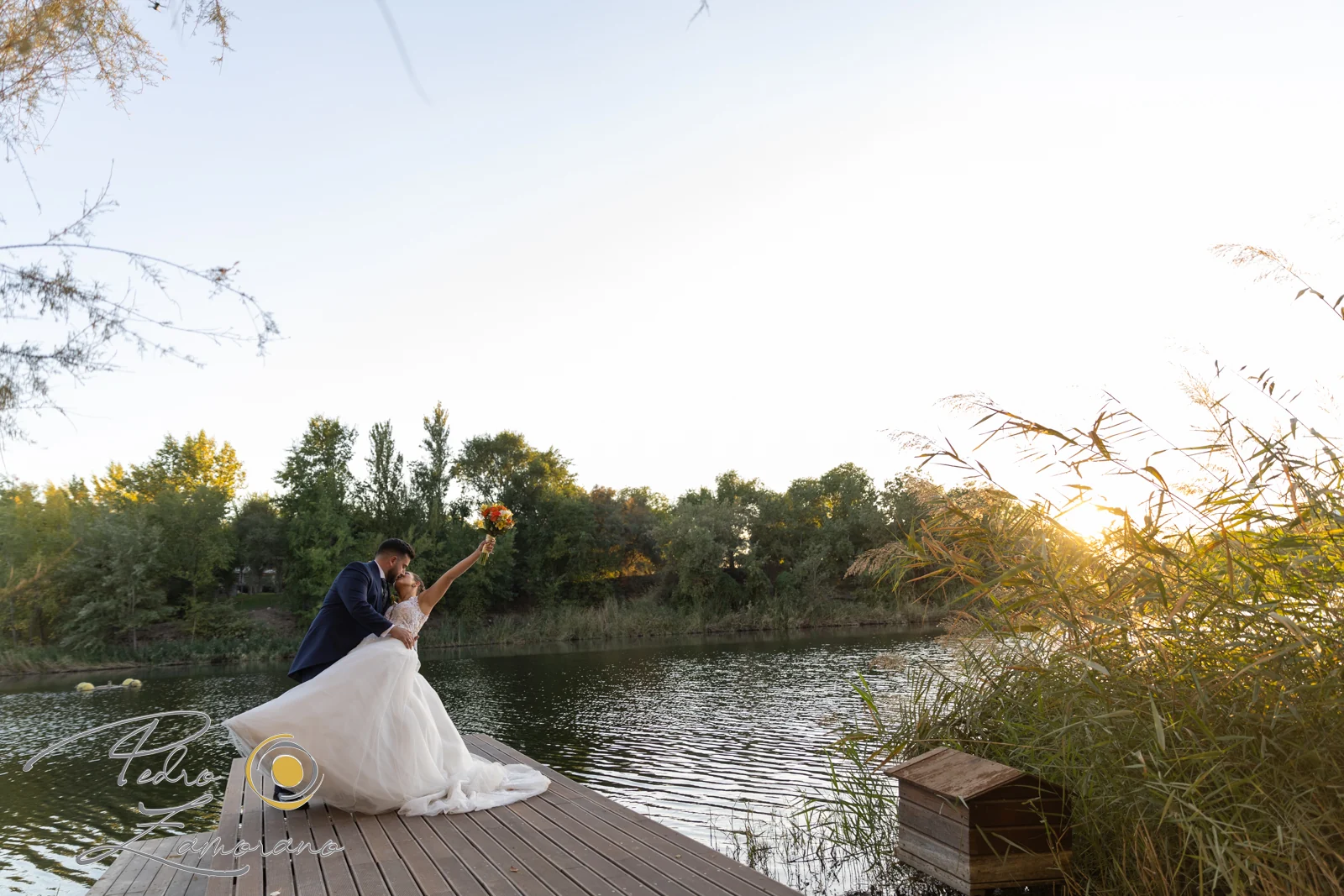 Novia junto al lago al atardecer en una boda en Complejo La Cigüeña