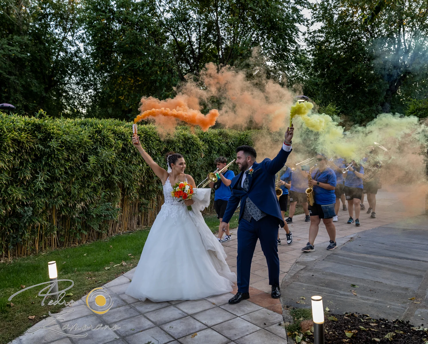 Novios celebrando con humo de colores en una boda en Complejo La Cigüeña