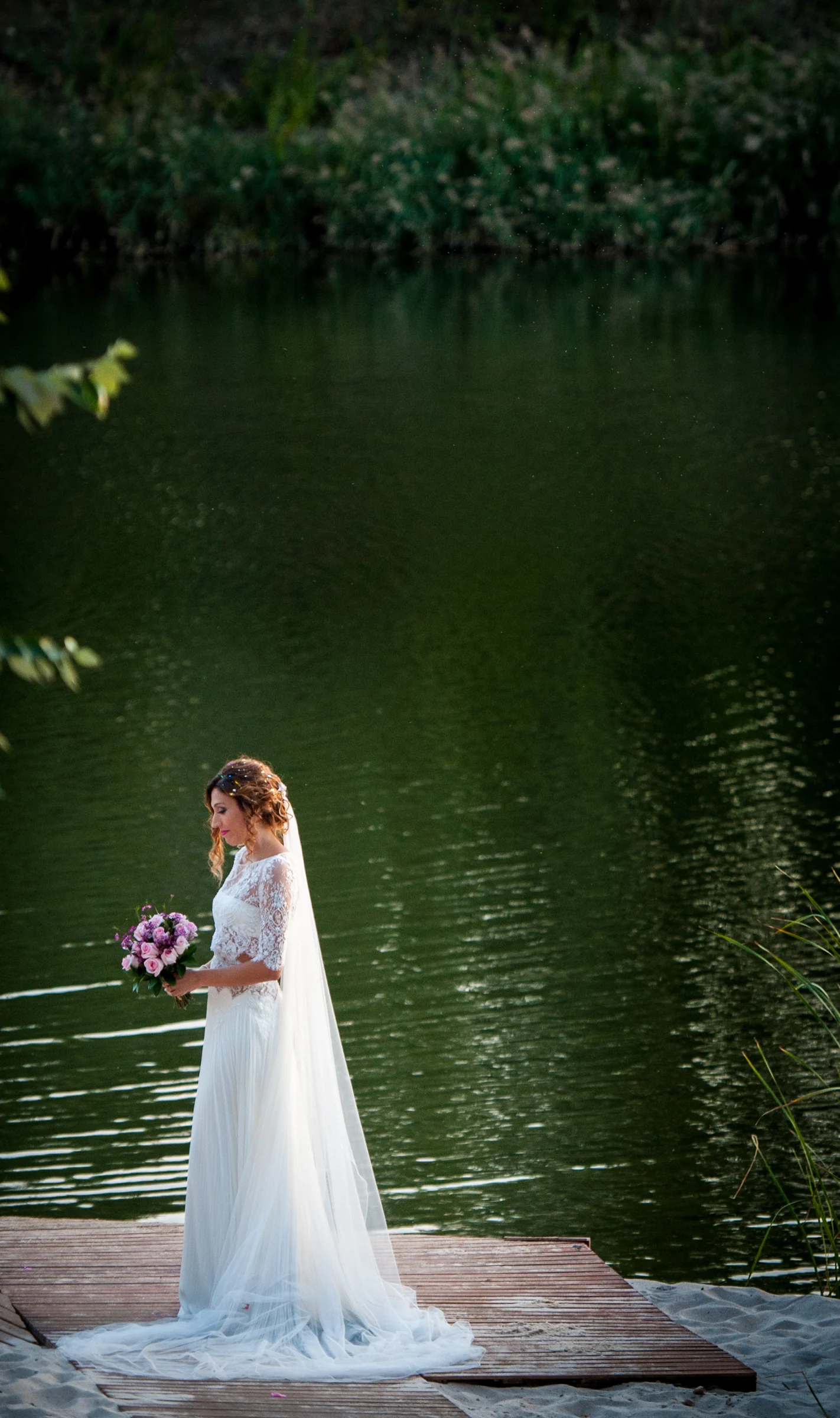 Novia sola junto al lago en una boda en Complejo La Cigüeña