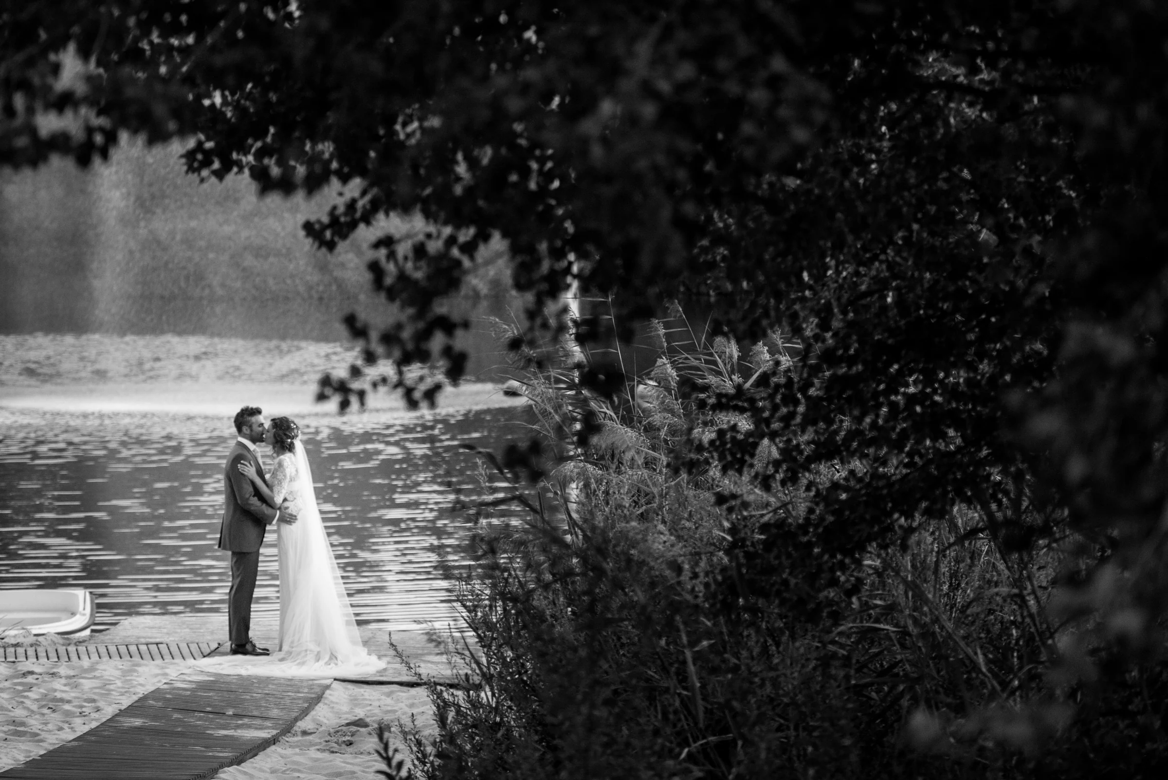 Novios junto al lago en blanco y negro en una boda en Complejo La Cigüeña