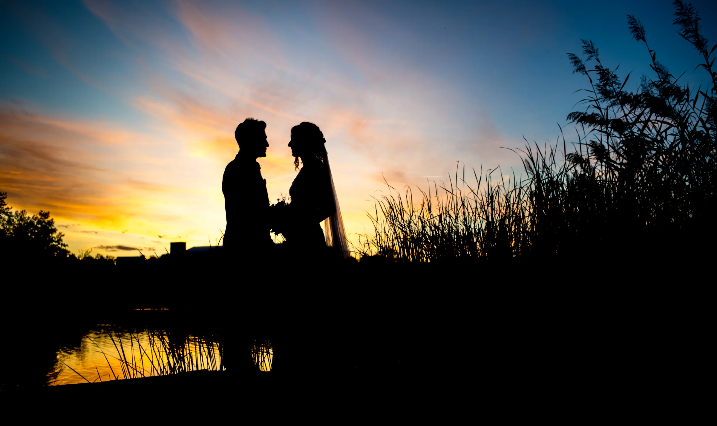 Silueta de los novios al atardecer en una boda en Complejo La Cigüeña