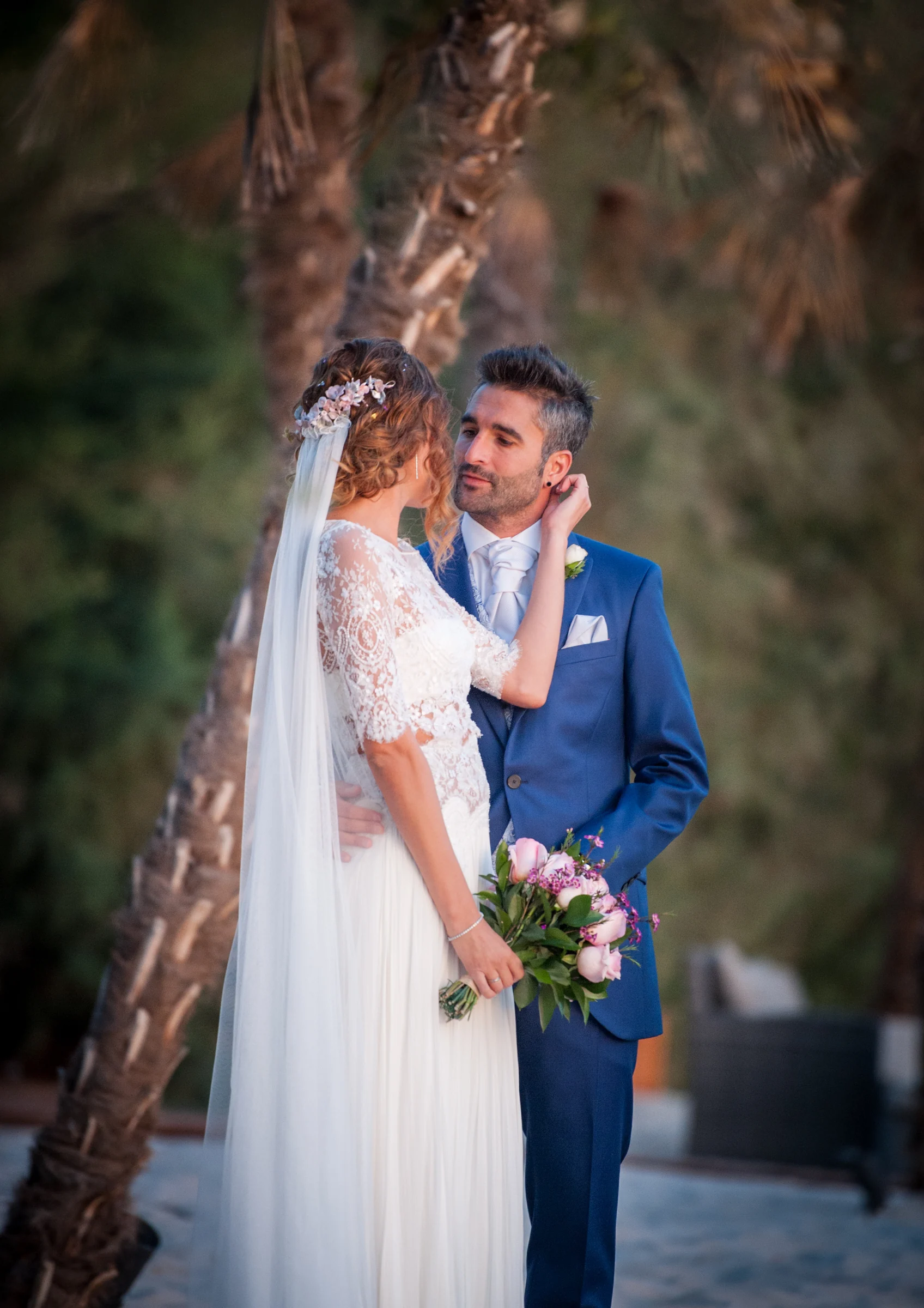 Novios abrazados junto a un árbol en una boda en Complejo La Cigüeña
