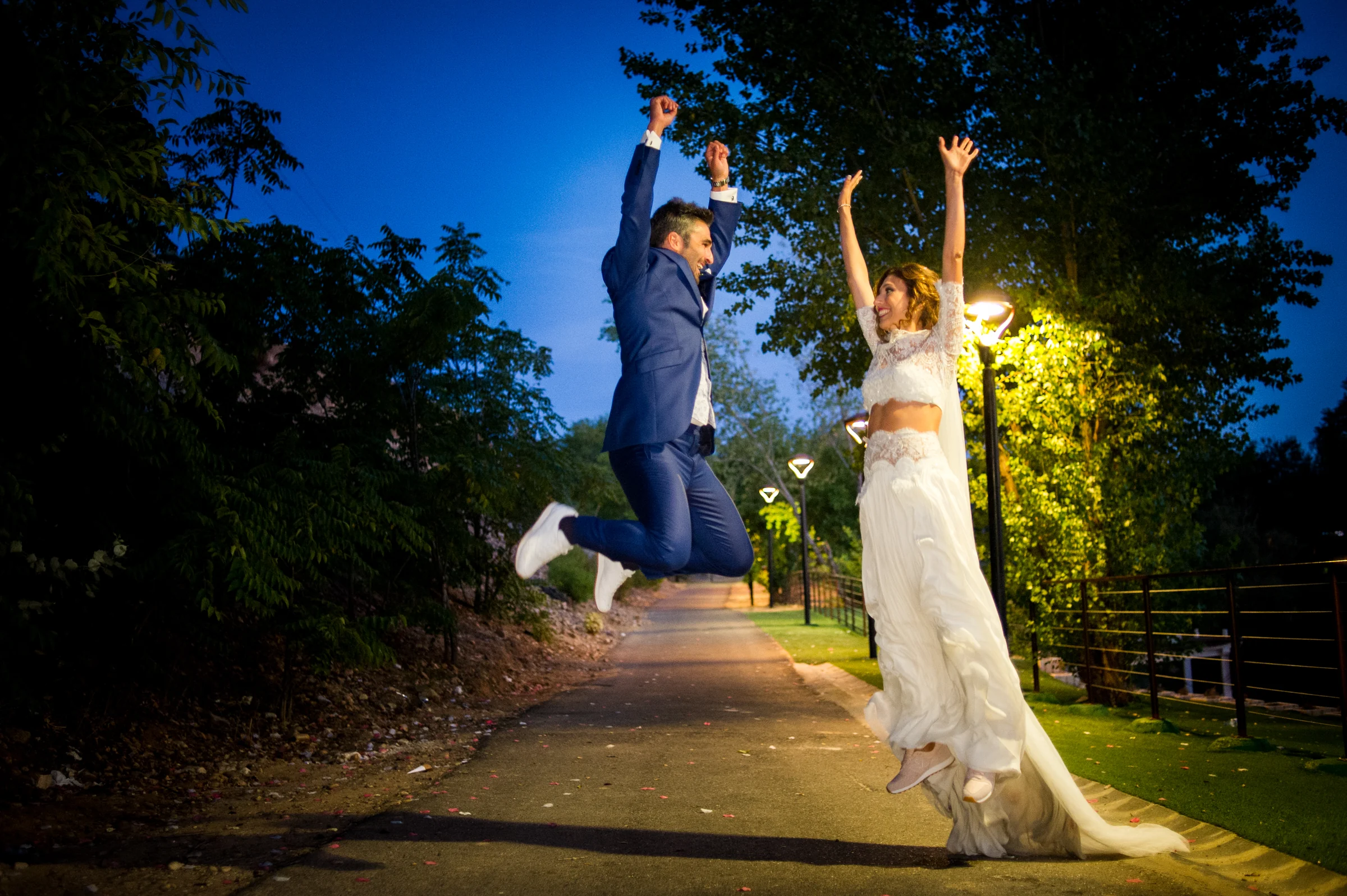 Novios saltando durante una sesión nocturna en una boda en Complejo La Cigüeña