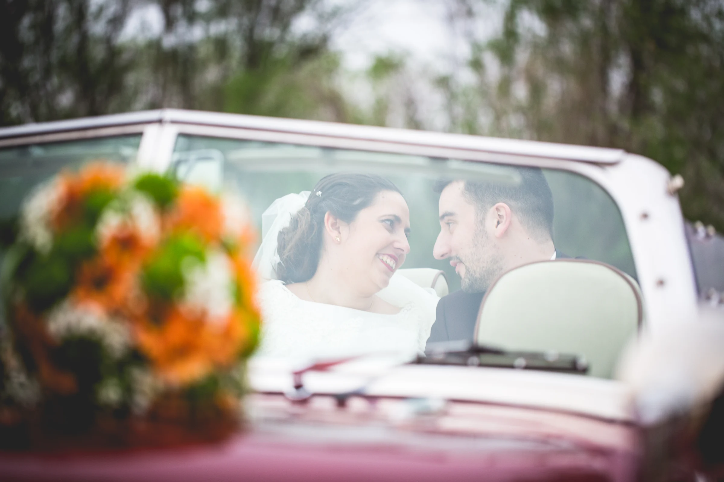 Novios dentro del coche clásico descapotable en una boda en Complejo La Cigüeña