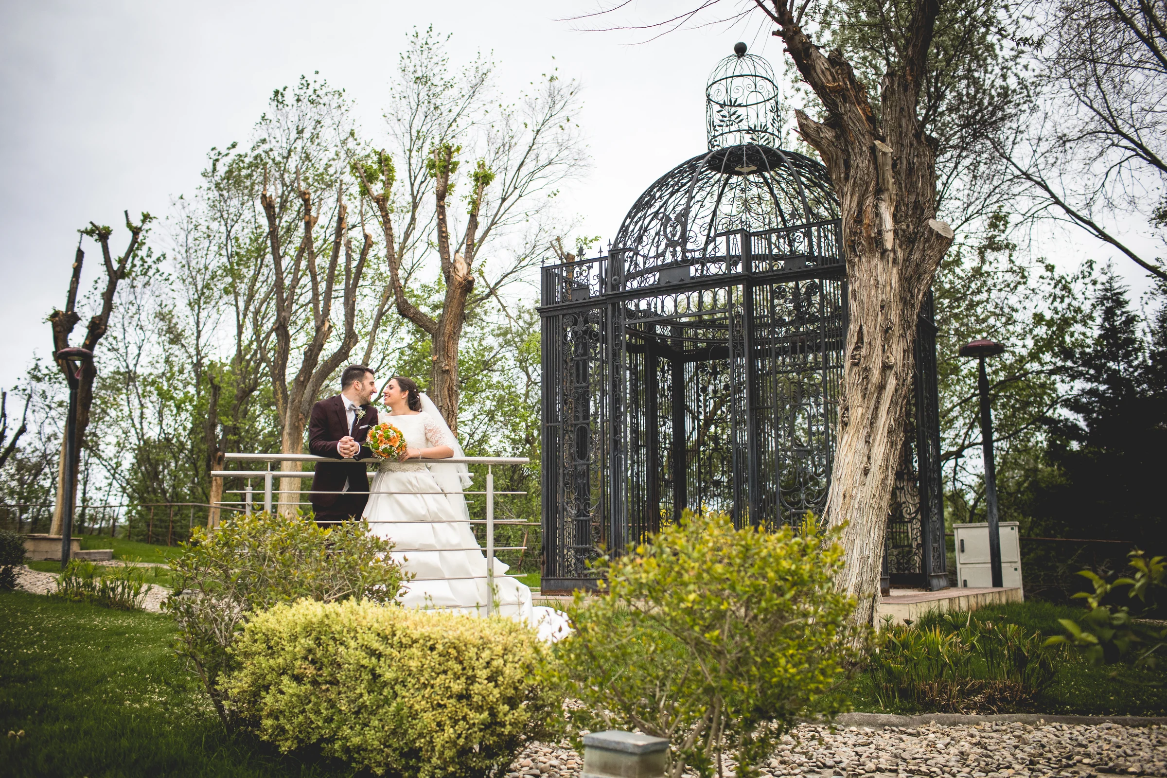 Novios ante una estructura de jardín en una boda en Complejo La Cigüeña