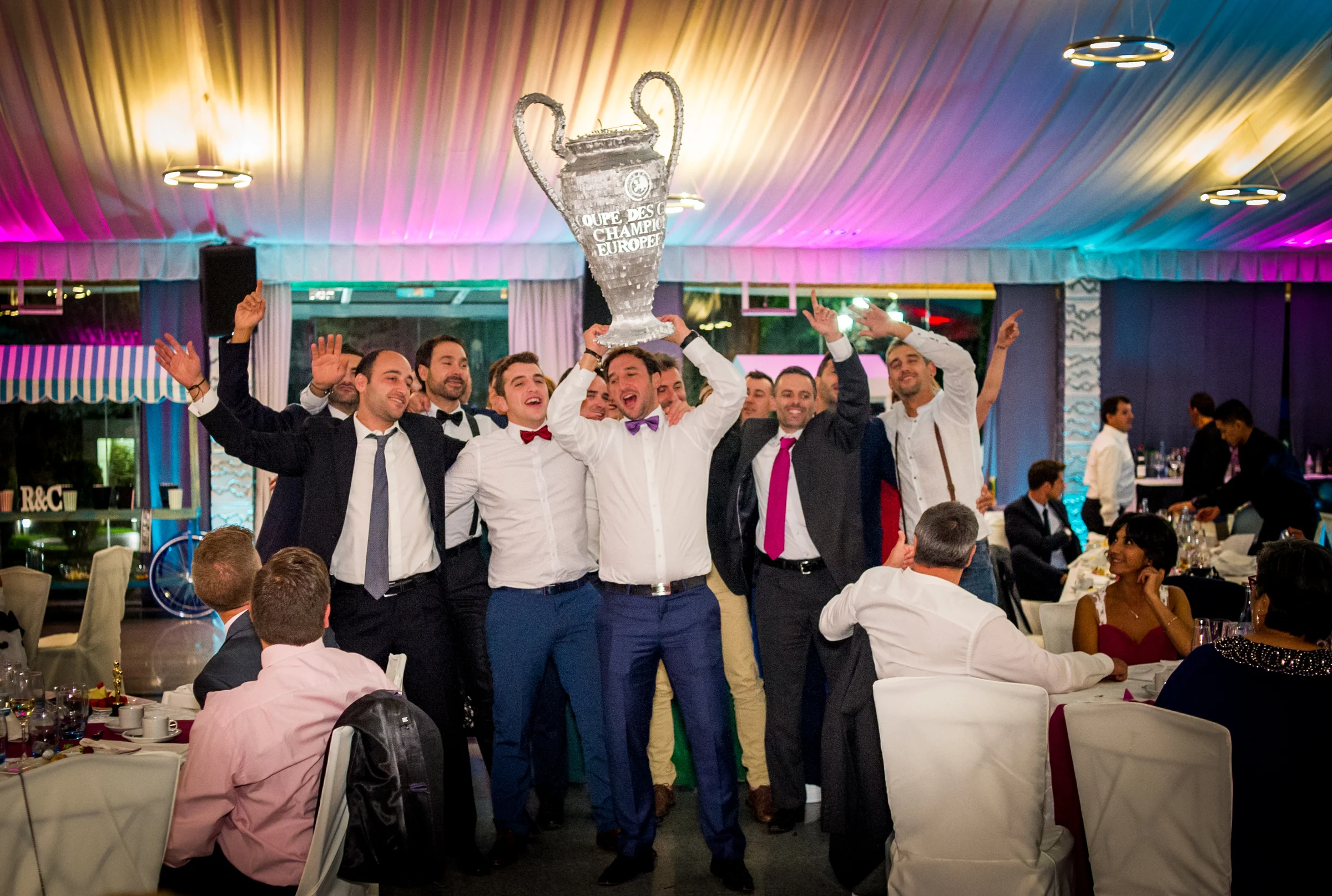 Grupo de amigos levantando al novio durante la fiesta en una boda en Complejo La Cigüeña