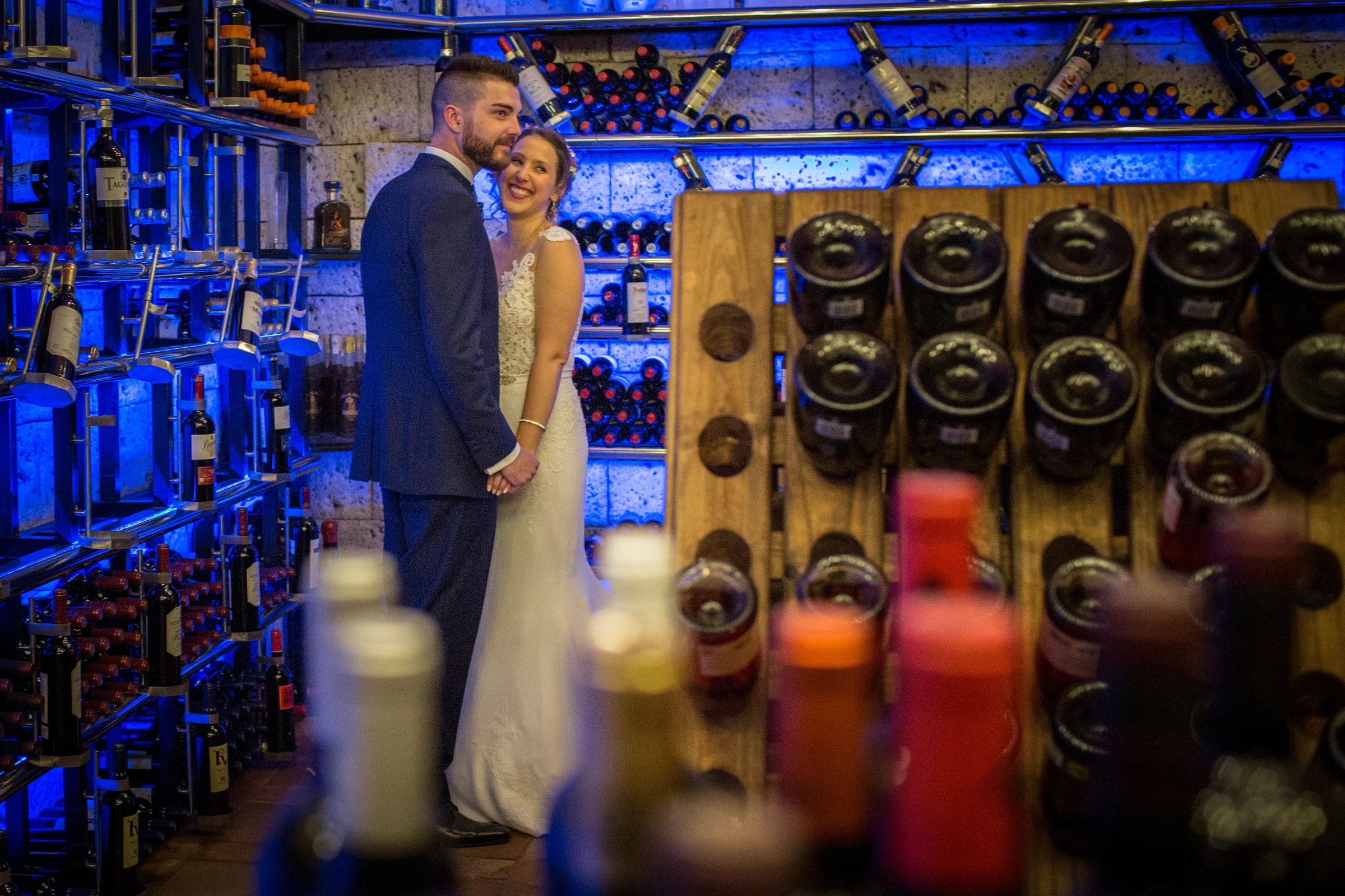 Novios en espacio interior con iluminación azul y decoración en una boda en Complejo La Cigüeña