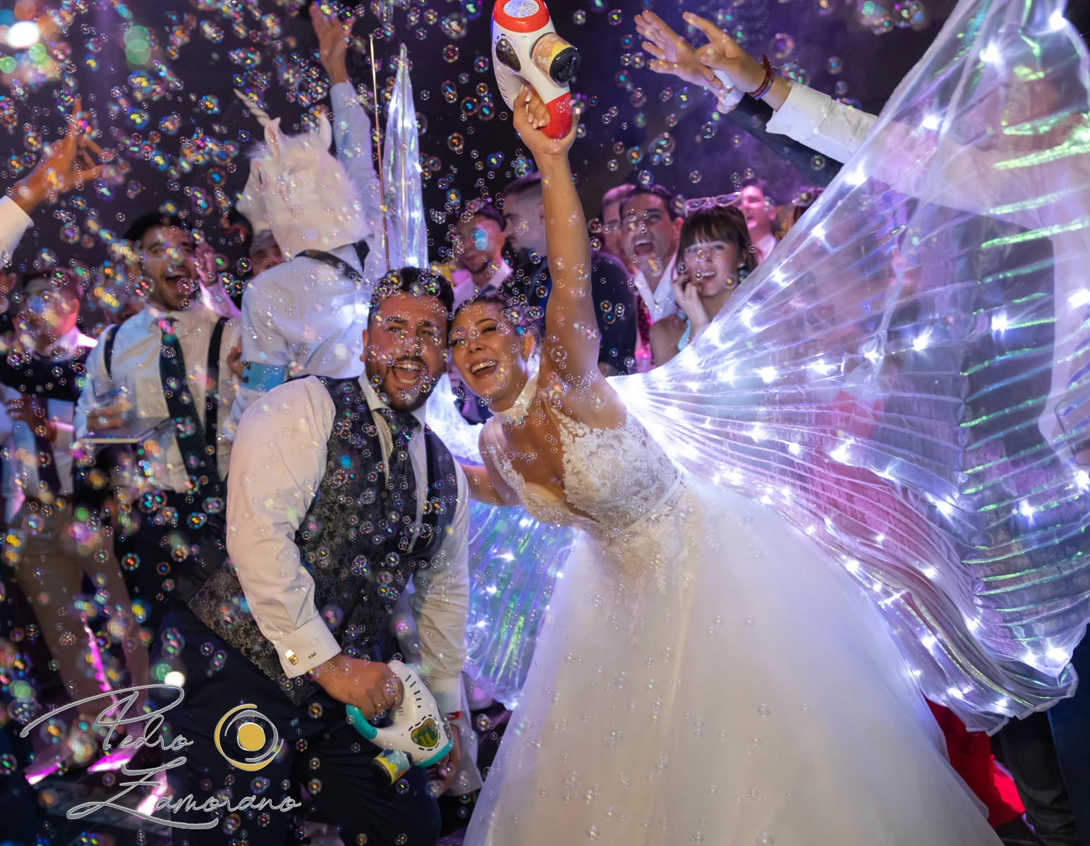 Novios celebrando bajo confeti y luces de fiesta en una boda en Complejo La Cigüeña