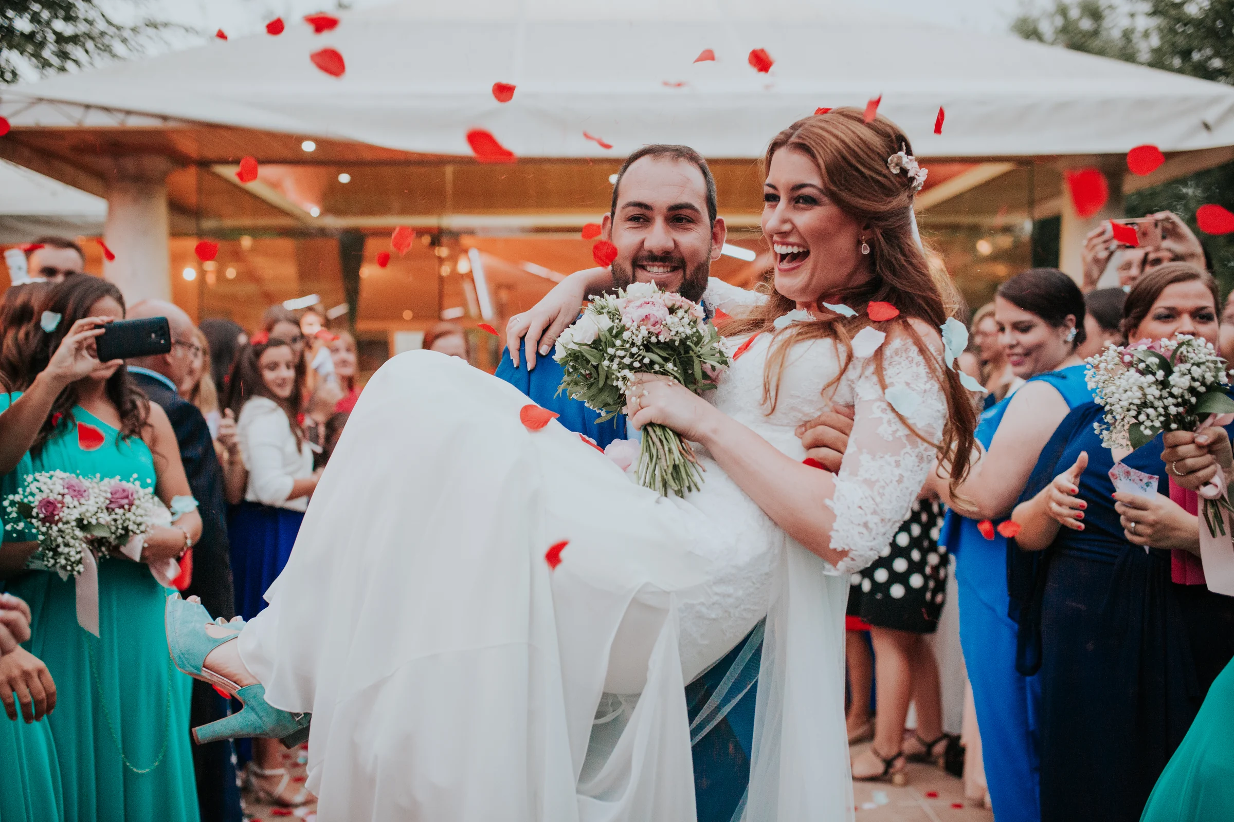 Novios saliendo entre pétalos y humo de colores en una boda en Complejo La Cigüeña