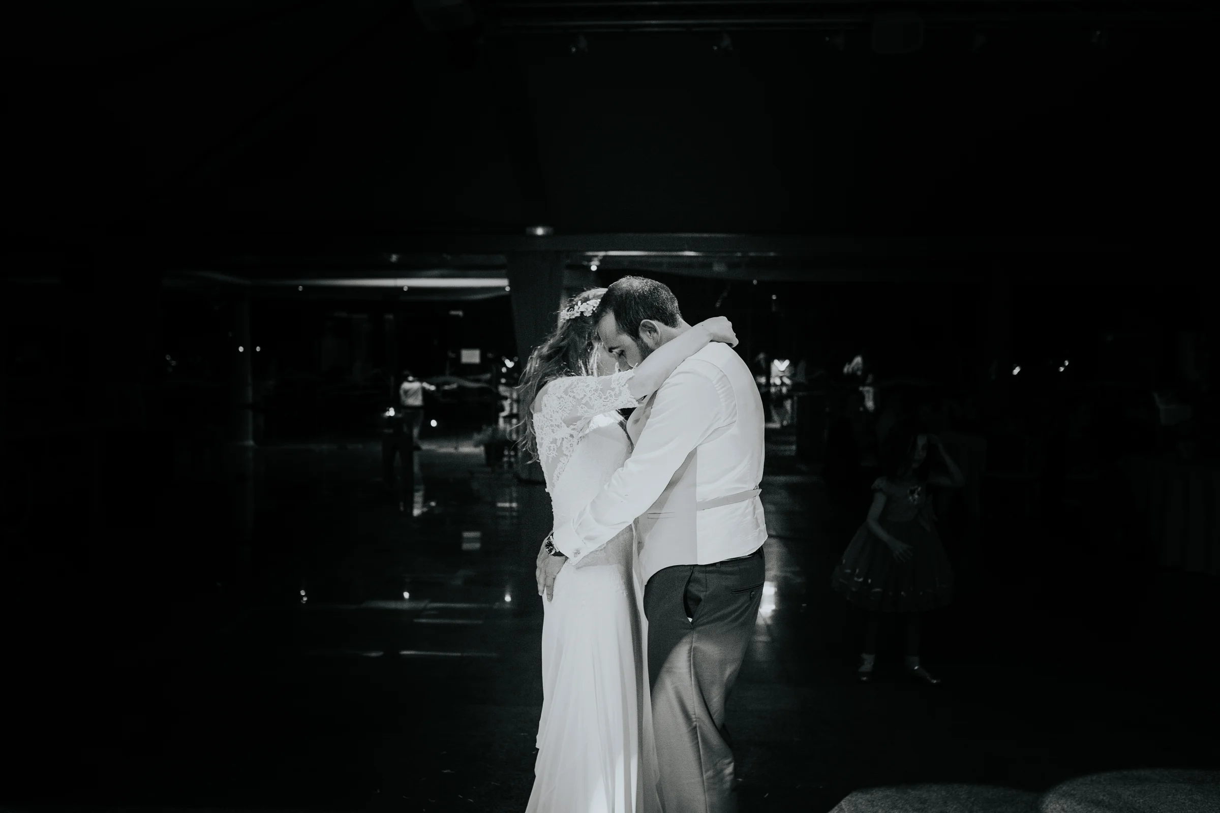 Abrazo emotivo durante la fiesta en blanco y negro en una boda en Complejo La Cigüeña