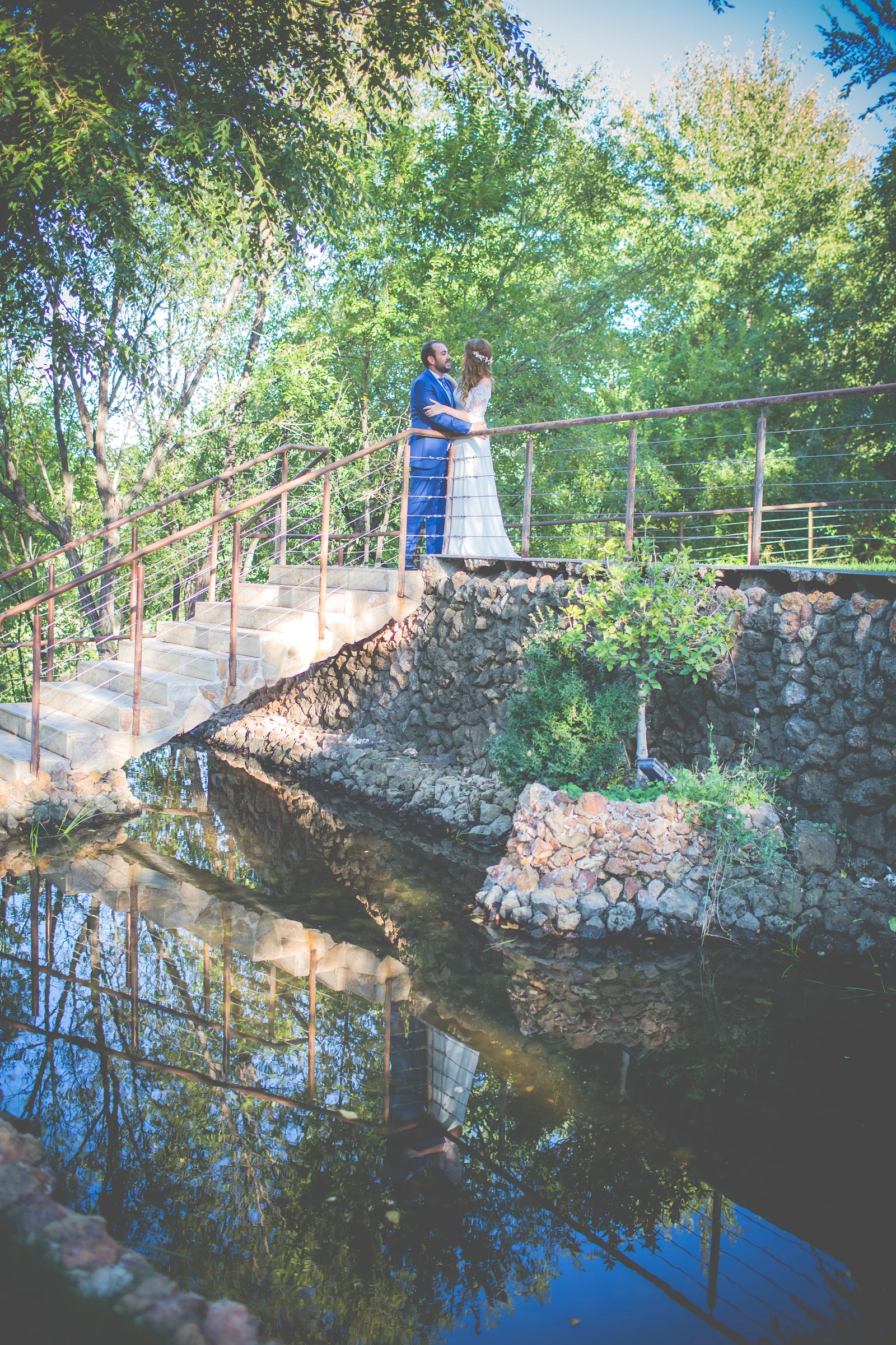 Novia sobre una pasarela de madera junto al lago en una boda en Complejo La Cigüeña