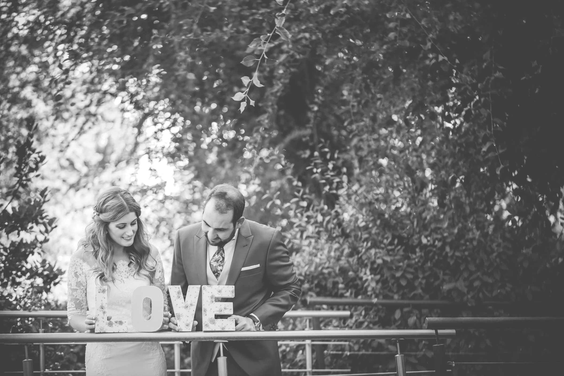 Novios junto a letras decorativas de amor en blanco y negro en una boda en Complejo La Cigüeña