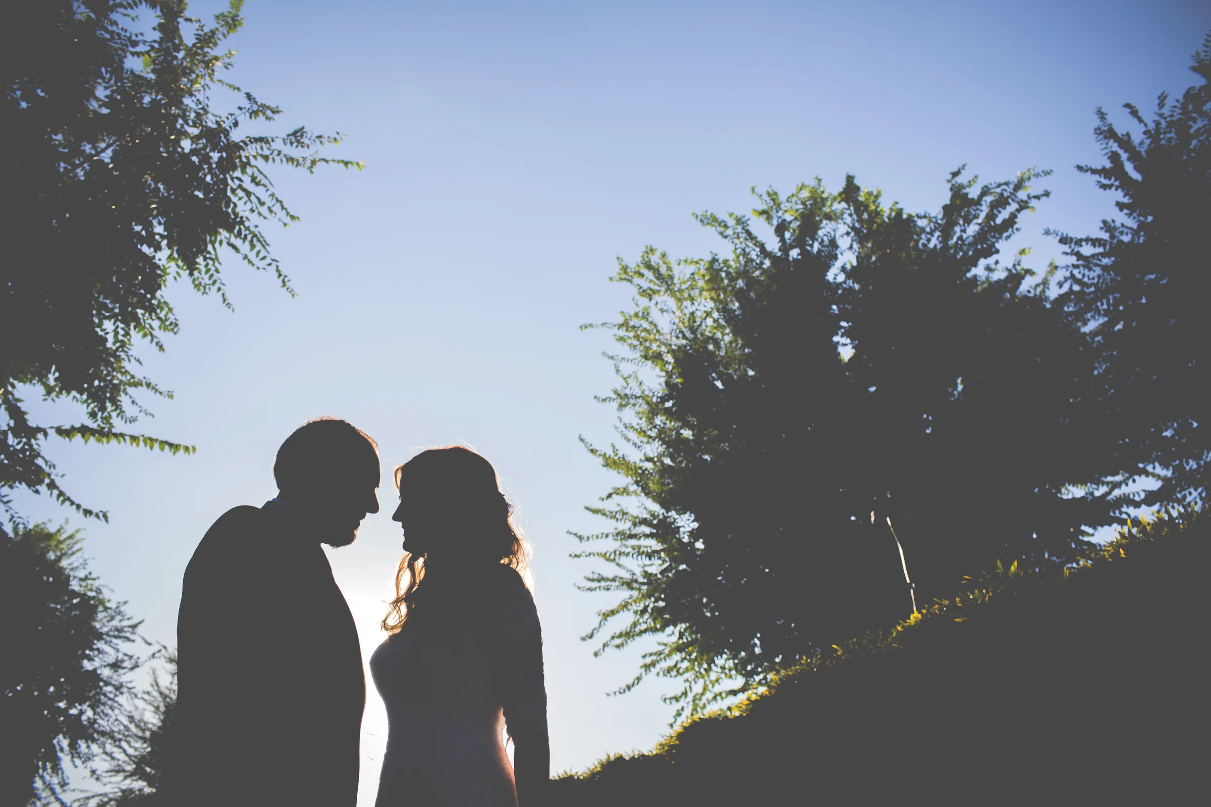 Silueta de los novios con contraluz en una boda en Complejo La Cigüeña
