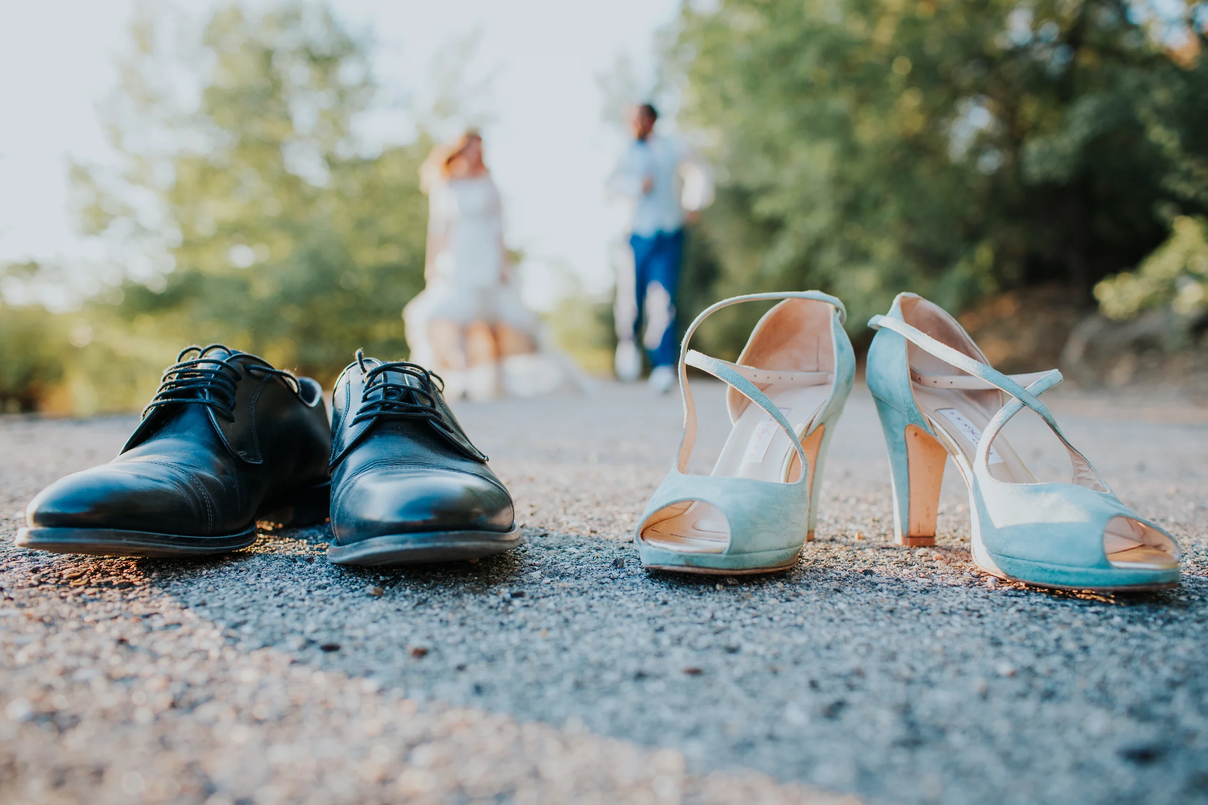 Zapatos de los novios con la pareja al fondo en una boda en Complejo La Cigüeña