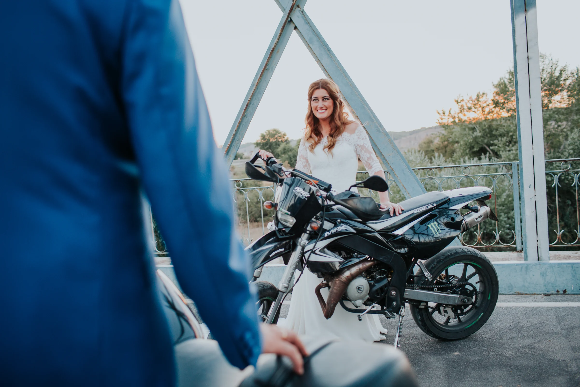 Novia junto a motocicleta en un puente en una boda en Complejo La Cigüeña