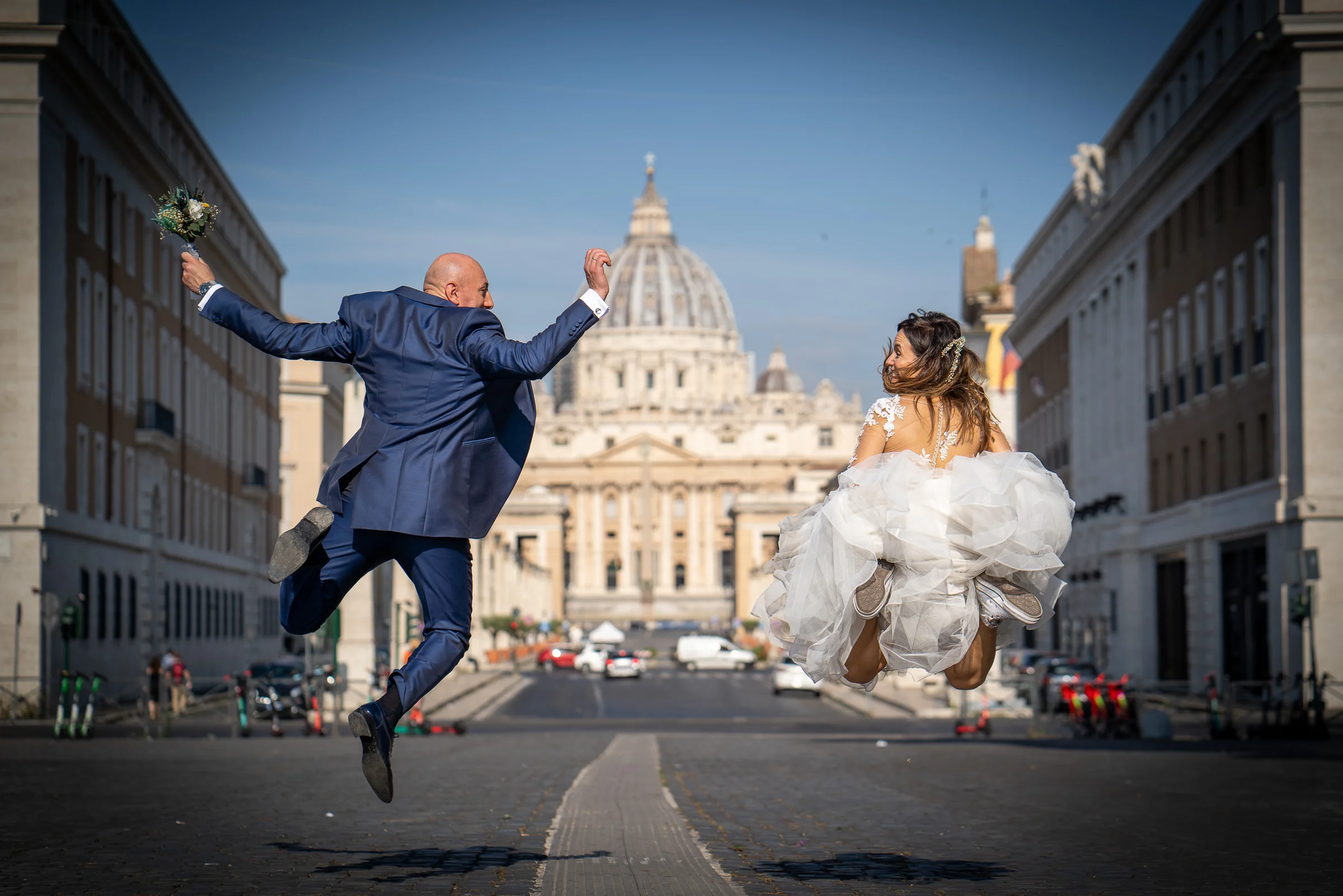 Marco y Esther saltan frente a la Basílica de San Pedro en una fotografía espontánea y divertida de su postboda.