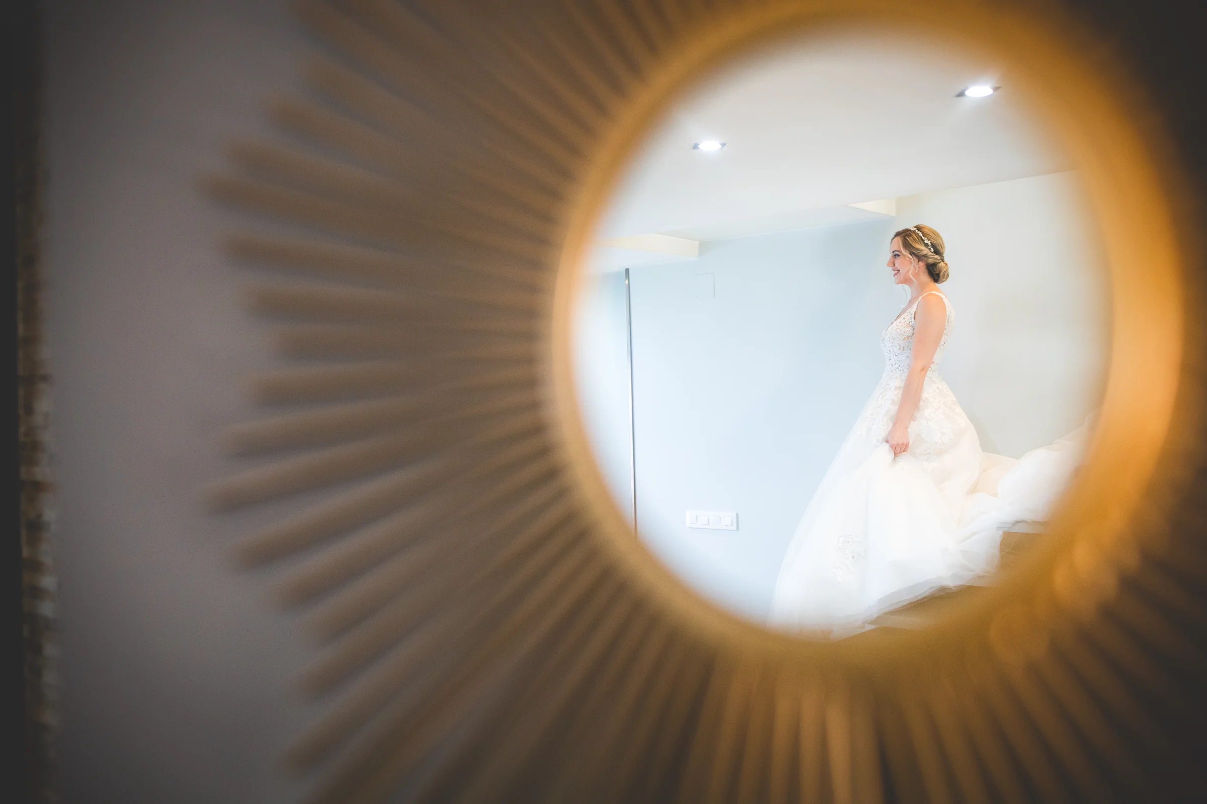 Novia reflejada en espejo circular durante una boda en Mirador de Cuatro Vientos.