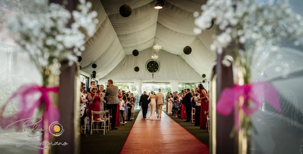 Entrada a ceremonia entre flores durante una boda en Mirador de Cuatro Vientos.