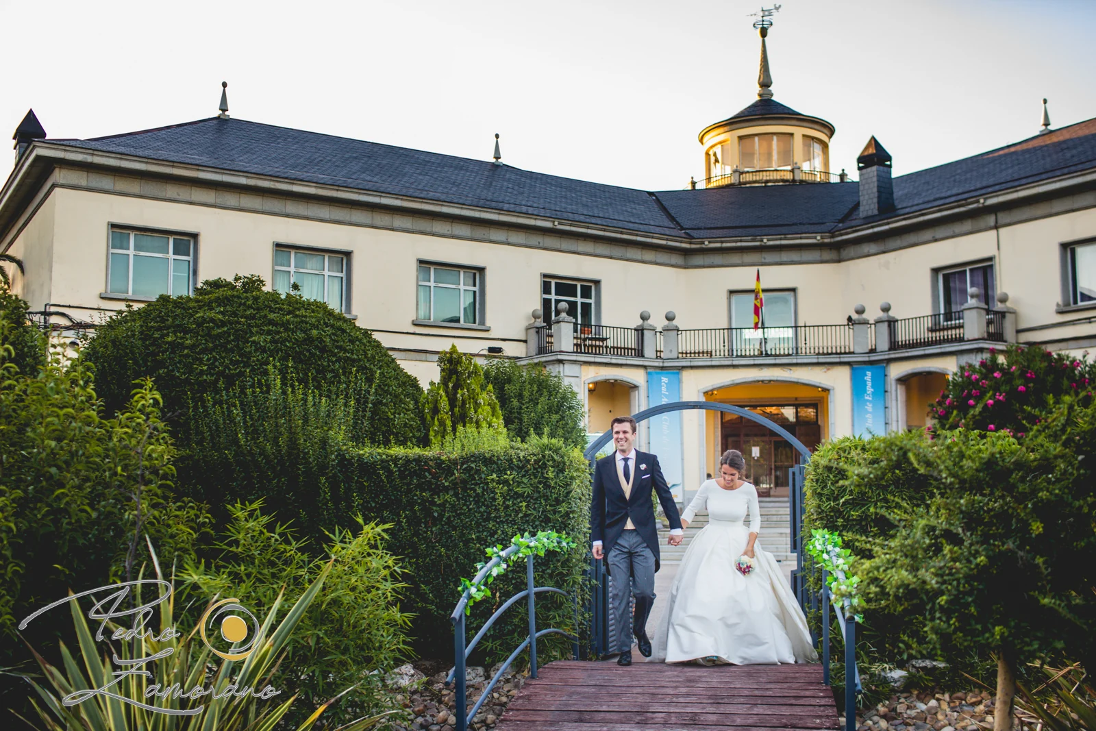 Novios saliendo del edificio principal durante una boda en Mirador de Cuatro Vientos.