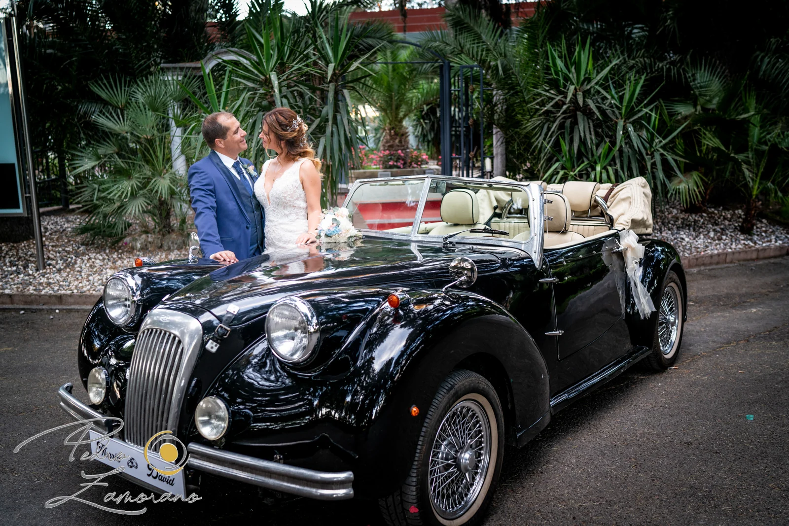 Novios junto a coche descapotable durante una boda en Mirador de Cuatro Vientos.