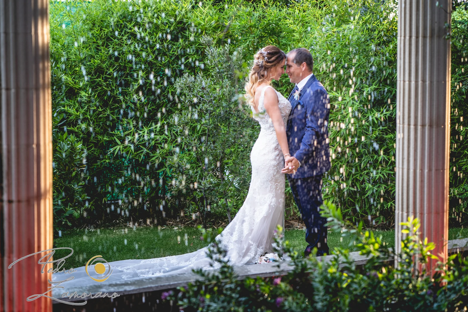 Novios bajo lluvia decorativa durante una boda en Mirador de Cuatro Vientos.