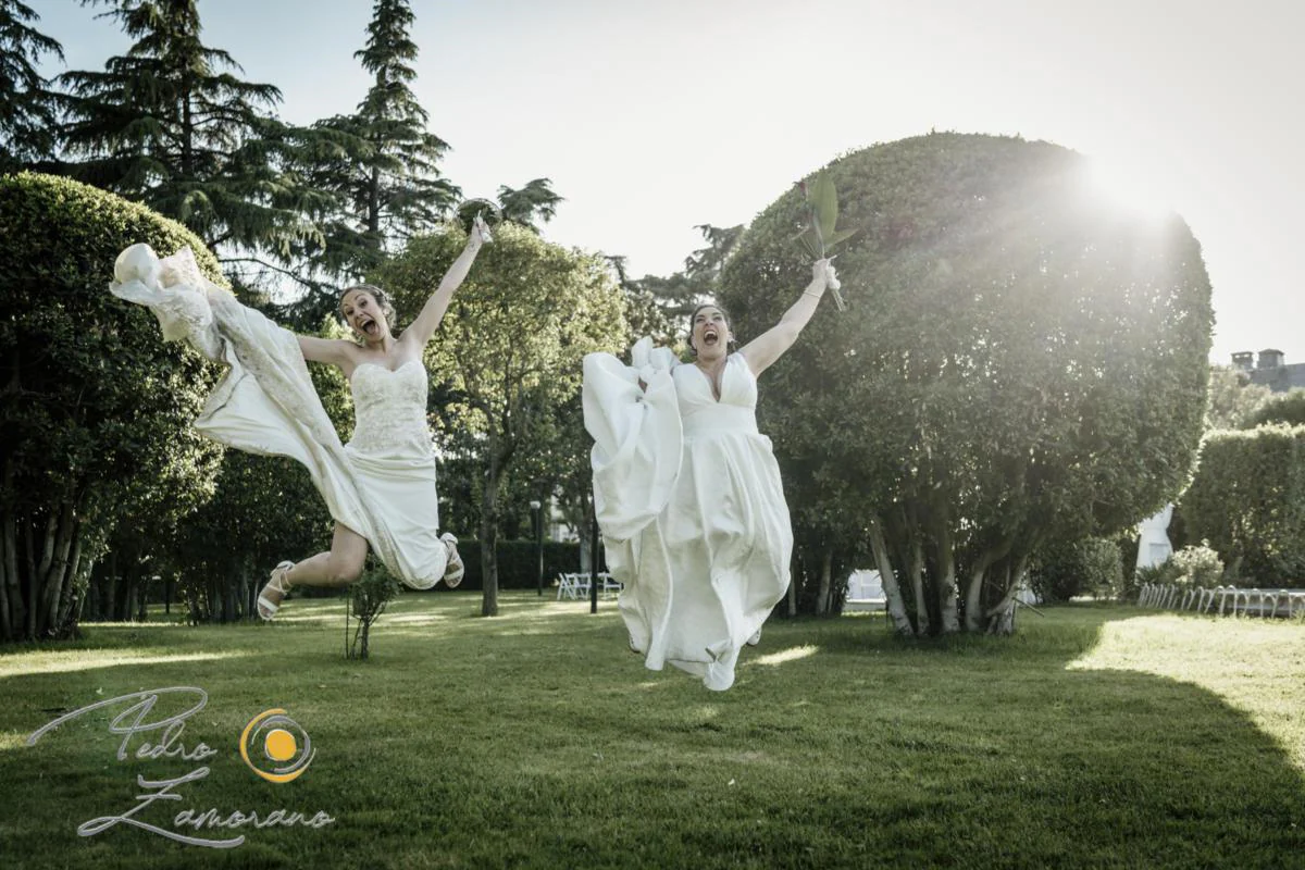 Dos novias saltando en los jardines durante una boda en Mirador de Cuatro Vientos.