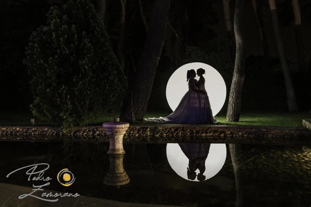 Silueta de dos novias con circulo de luz durante una boda en Mirador de Cuatro Vientos.