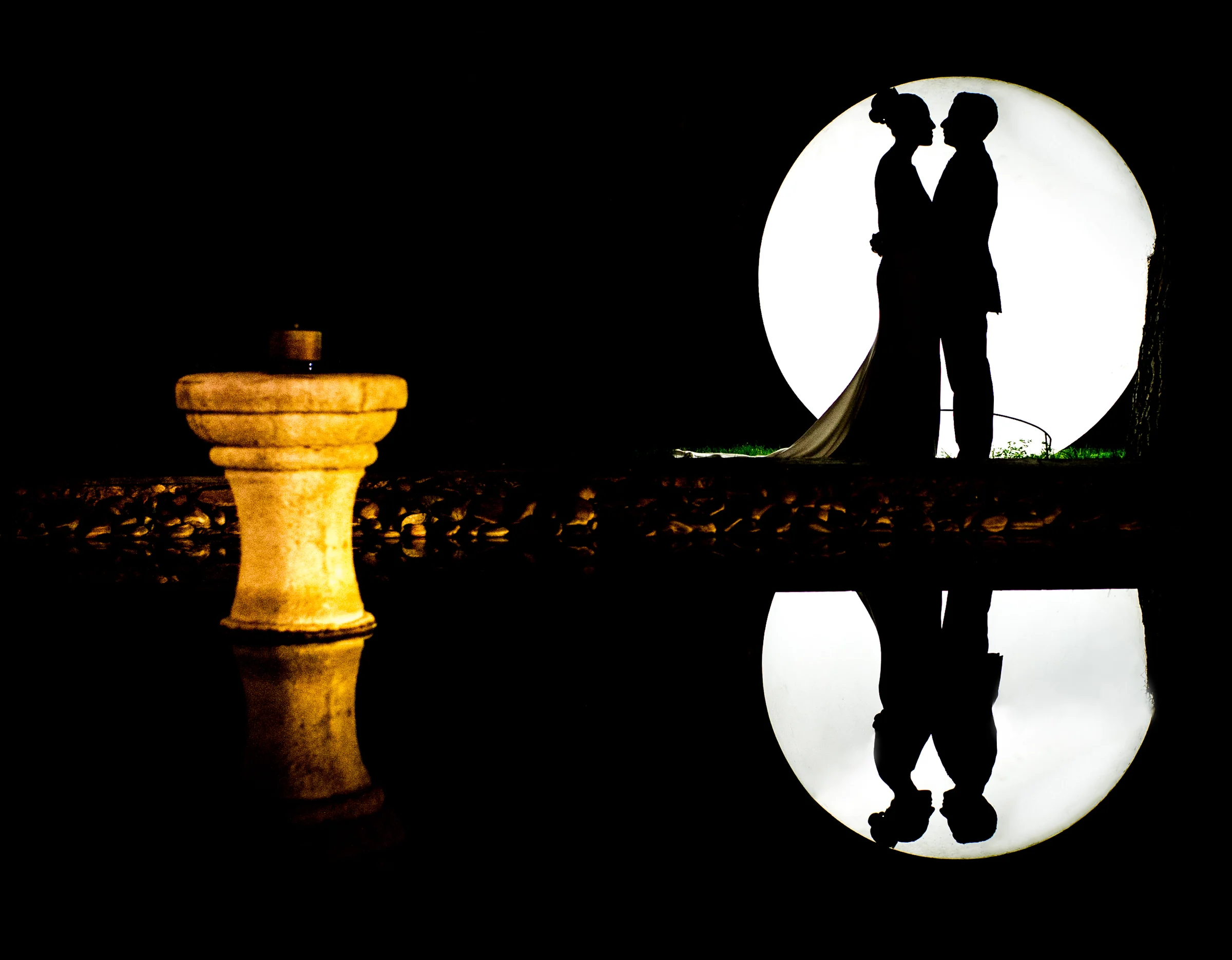 Silueta de novios con reflejo nocturno durante una boda en Mirador de Cuatro Vientos.