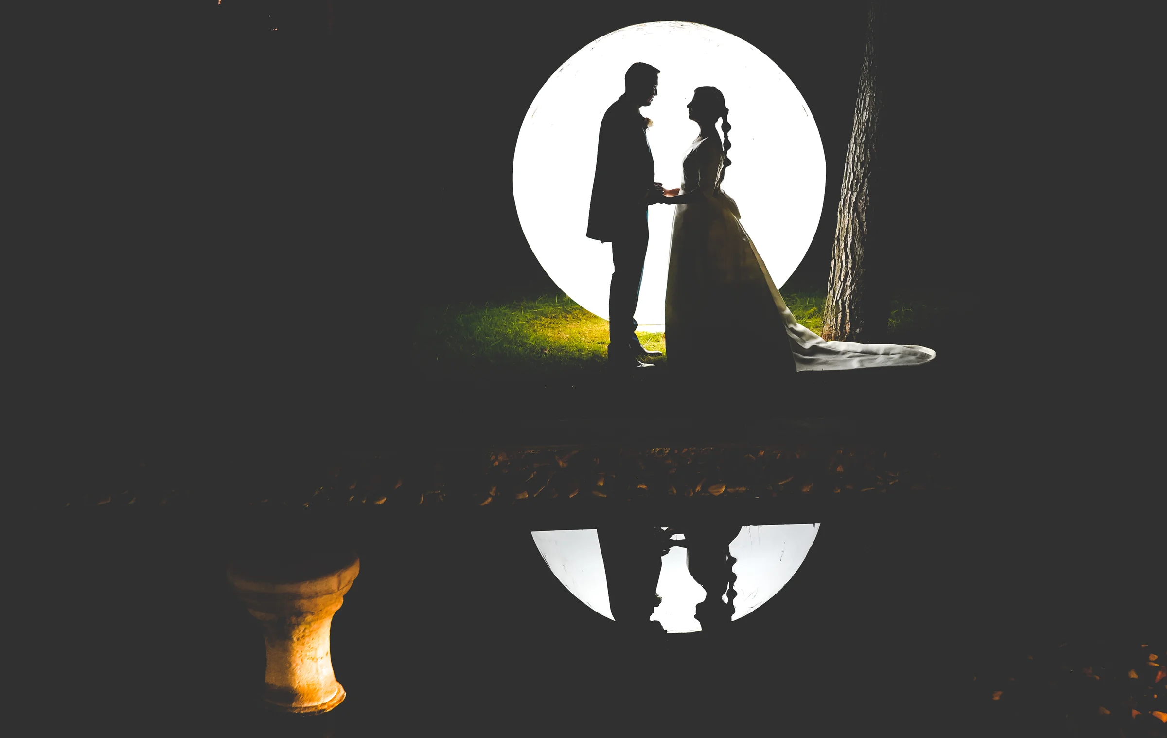 Silueta nocturna de novios con circulo de luz durante una boda en Mirador de Cuatro Vientos.