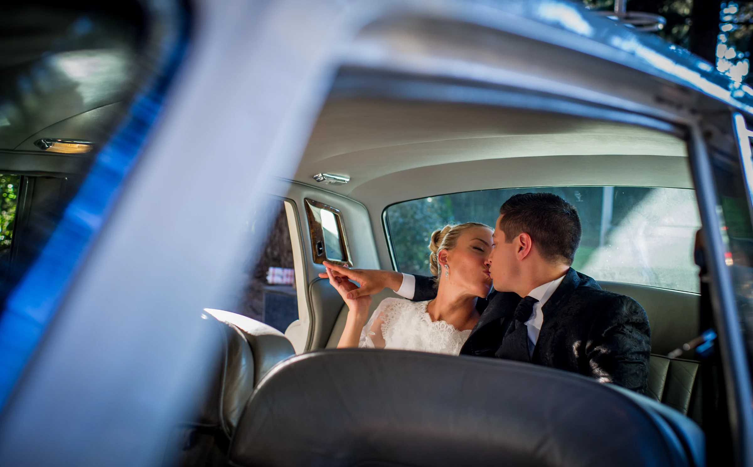 Beso de novios dentro de coche clasico durante una boda en Mirador de Cuatro Vientos.