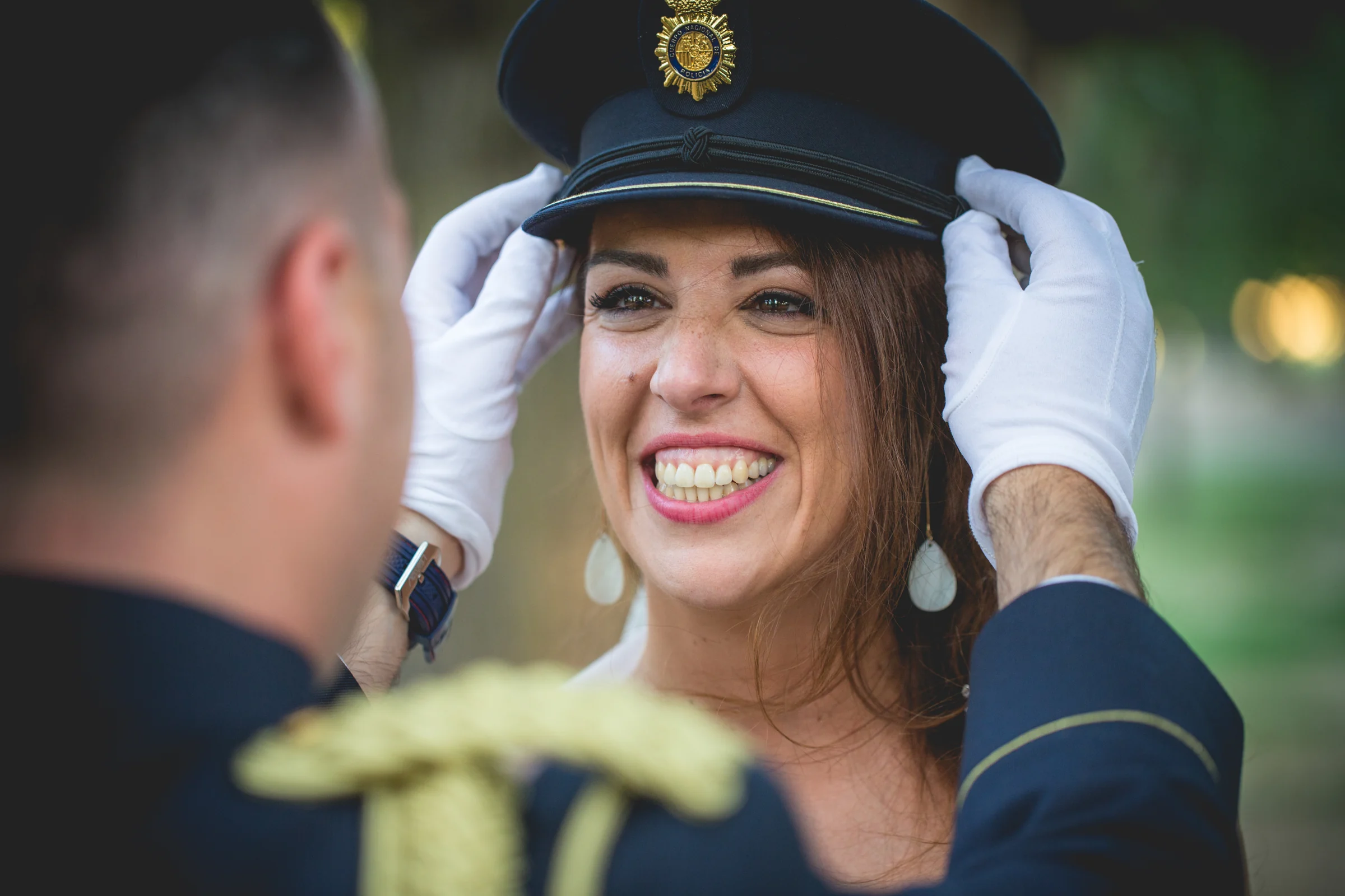 Novio colocando gorra de uniforme a la novia durante una boda en Mirador de Cuatro Vientos.