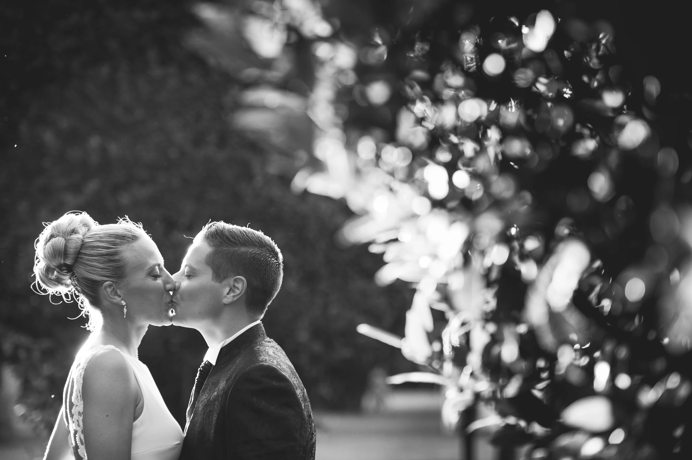 Beso de novios en blanco y negro con bokeh durante una boda en Mirador de Cuatro Vientos.