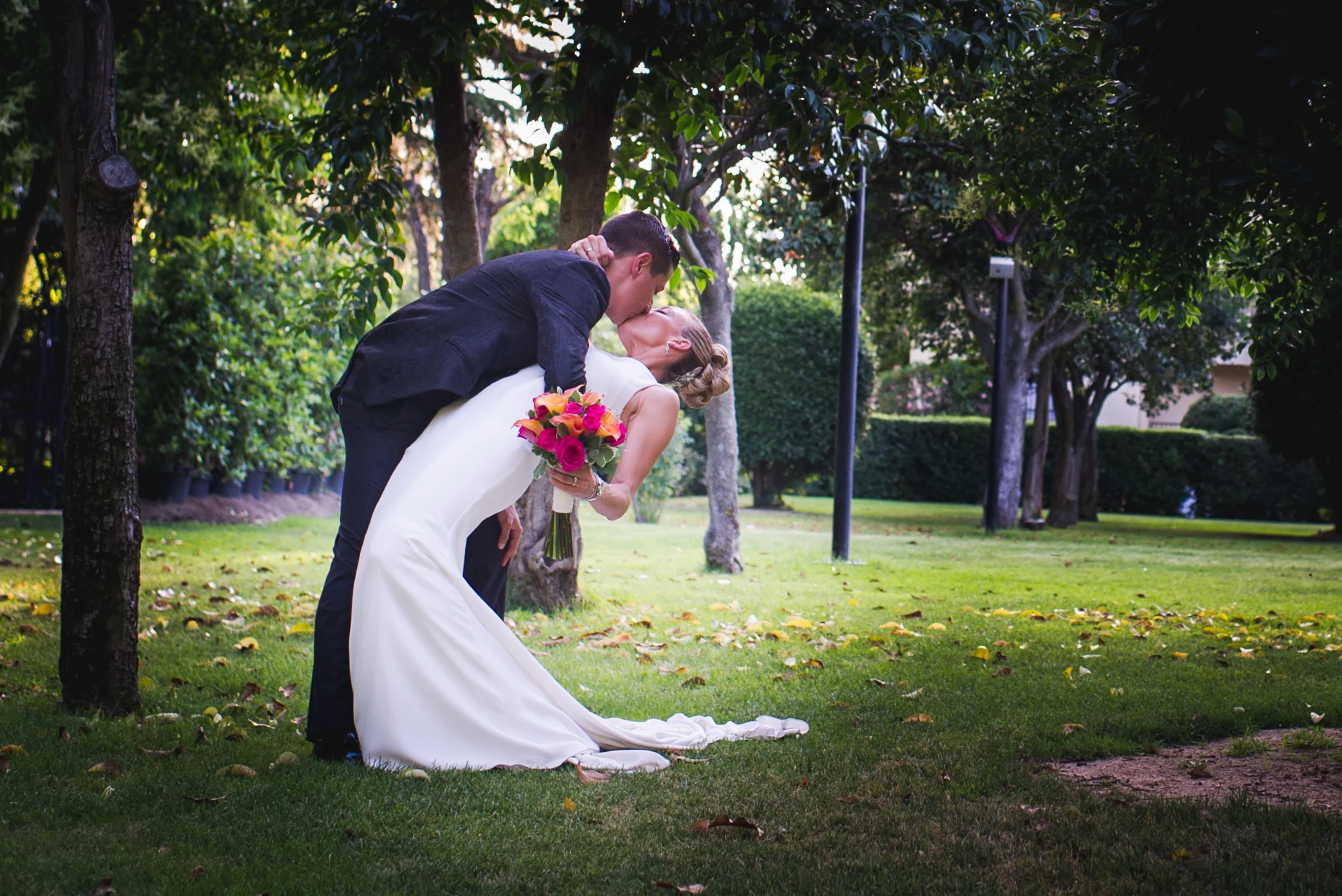 Beso inclinado de los novios en el jardin durante una boda en Mirador de Cuatro Vientos.