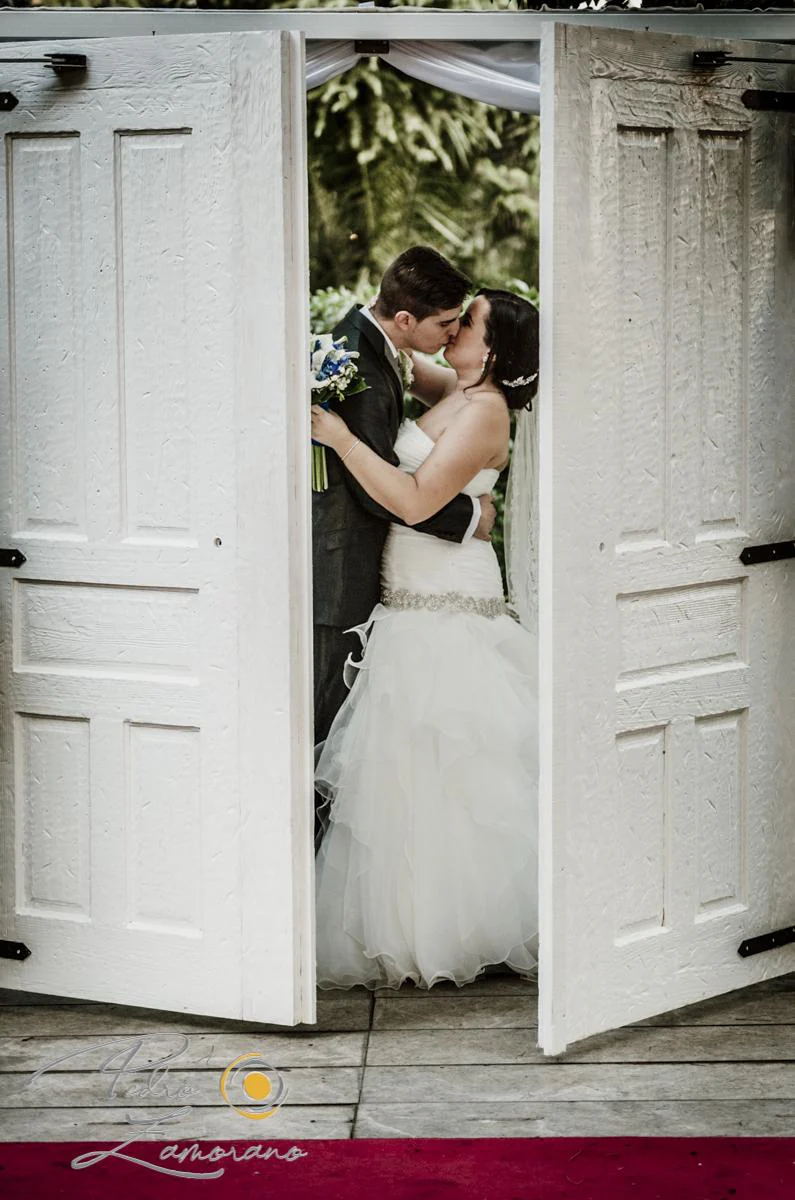 Beso de novios entre puertas durante una boda en Mirador de Cuatro Vientos.