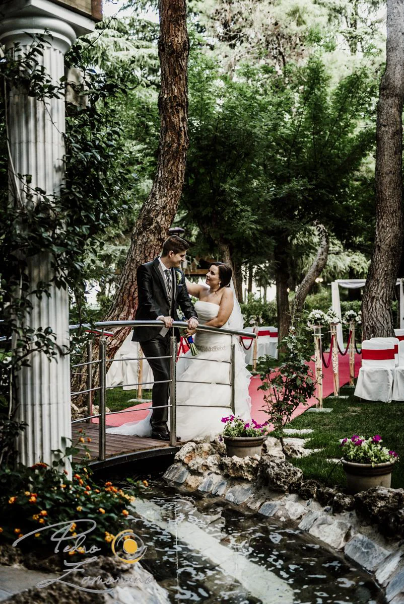 Novios junto a puente y estanque vertical durante una boda en Mirador de Cuatro Vientos.