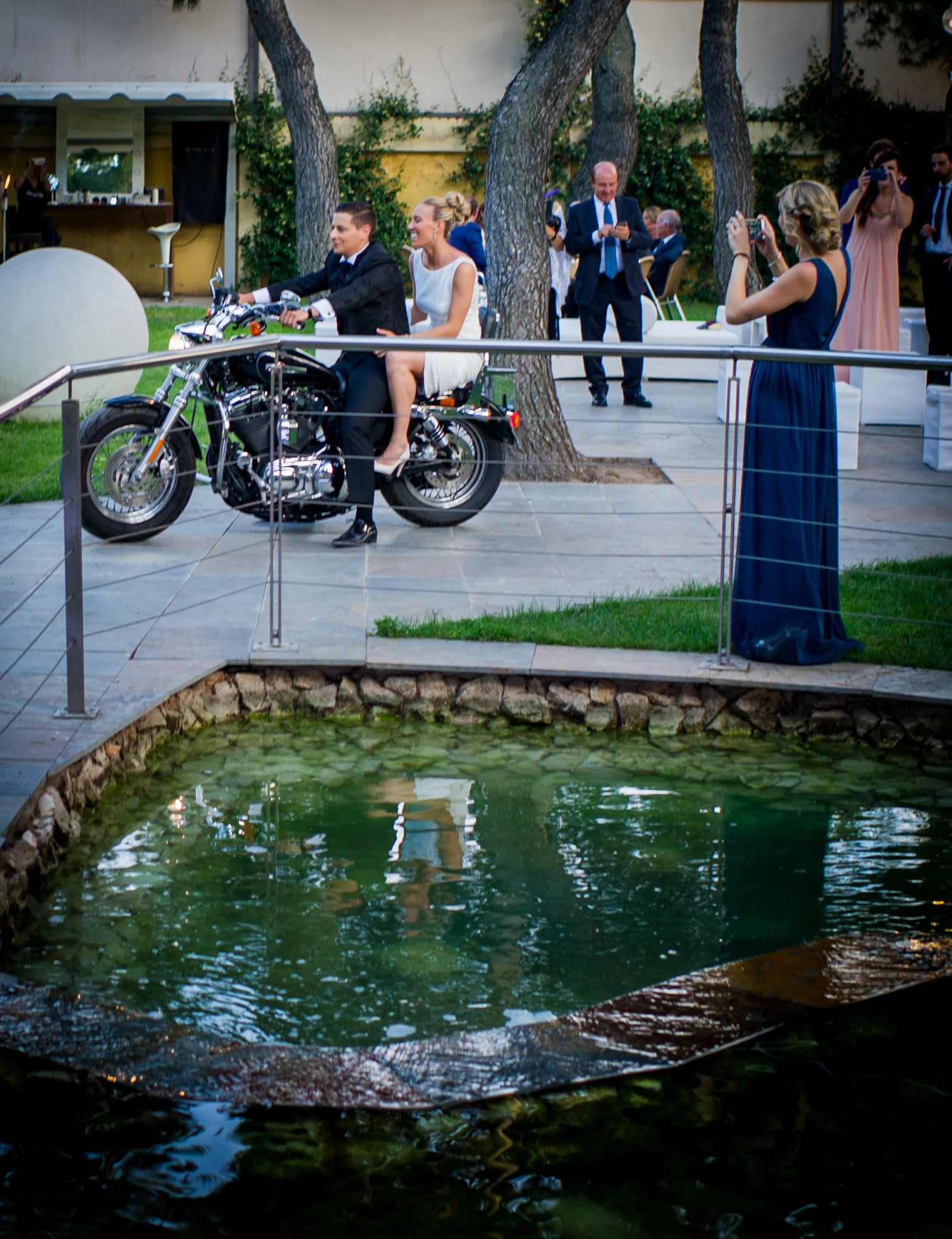 Novios en moto junto al estanque durante una boda en Mirador de Cuatro Vientos.