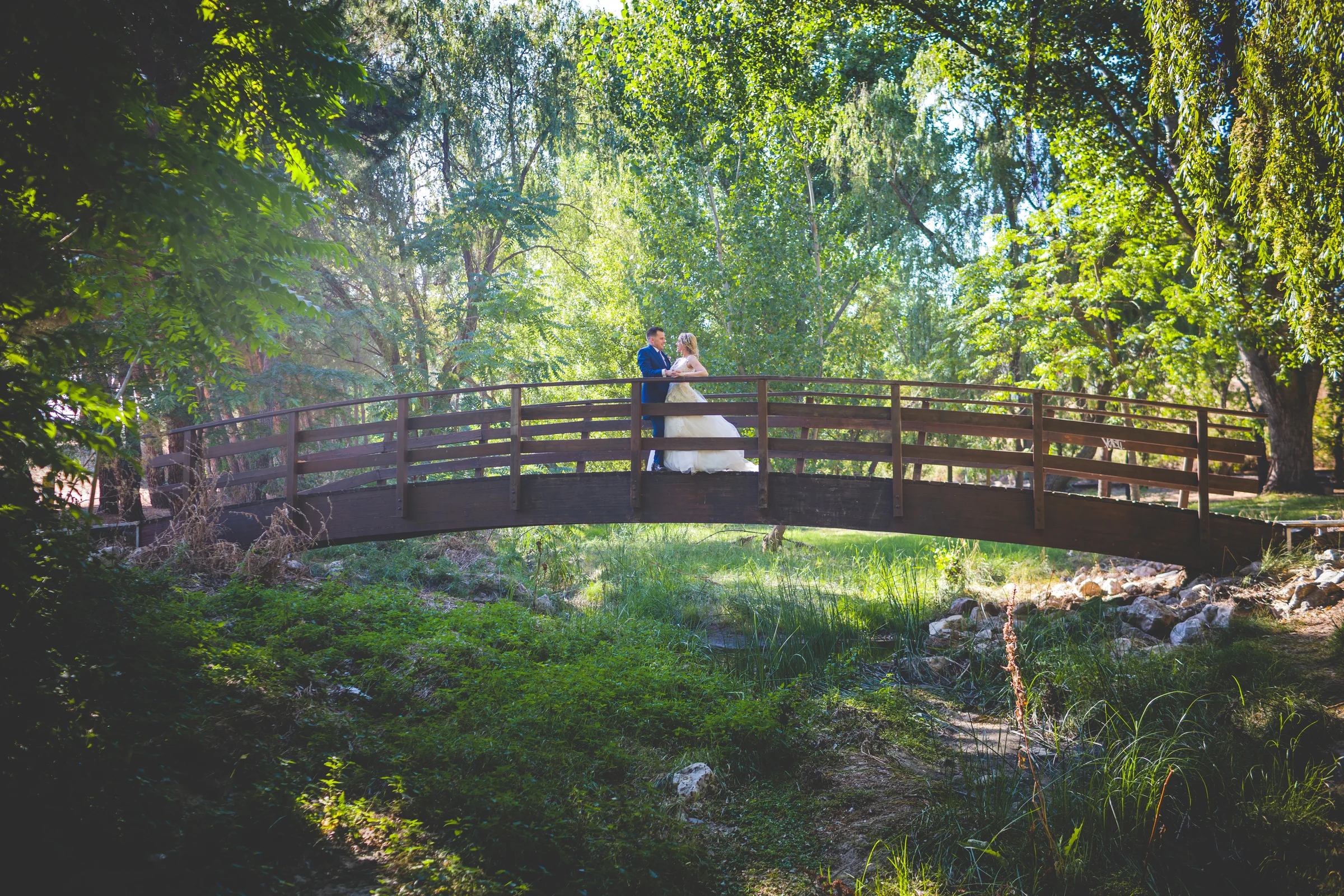 Novios sobre puente en paisaje verde durante una boda en Mirador de Cuatro Vientos.