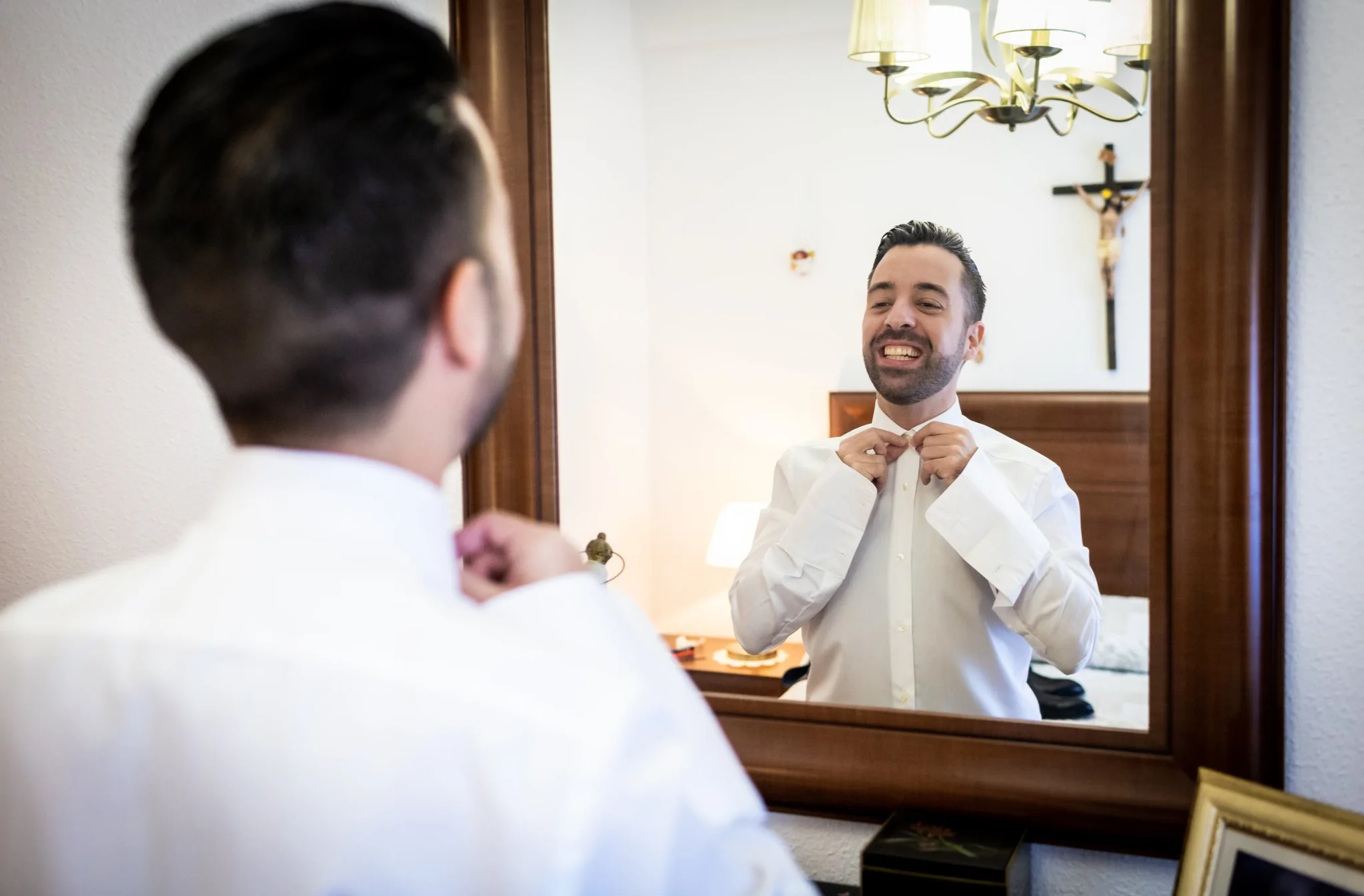 Novio ajustándose la corbata frente al espejo en una boda en Peñarrubia de Araceli, fotografía de Pedro Zamorano.