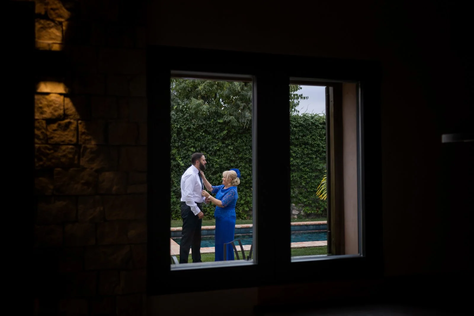 Novio conversando con su madre en el jardín en una boda en Peñarrubia de Araceli, fotografía de Pedro Zamorano.