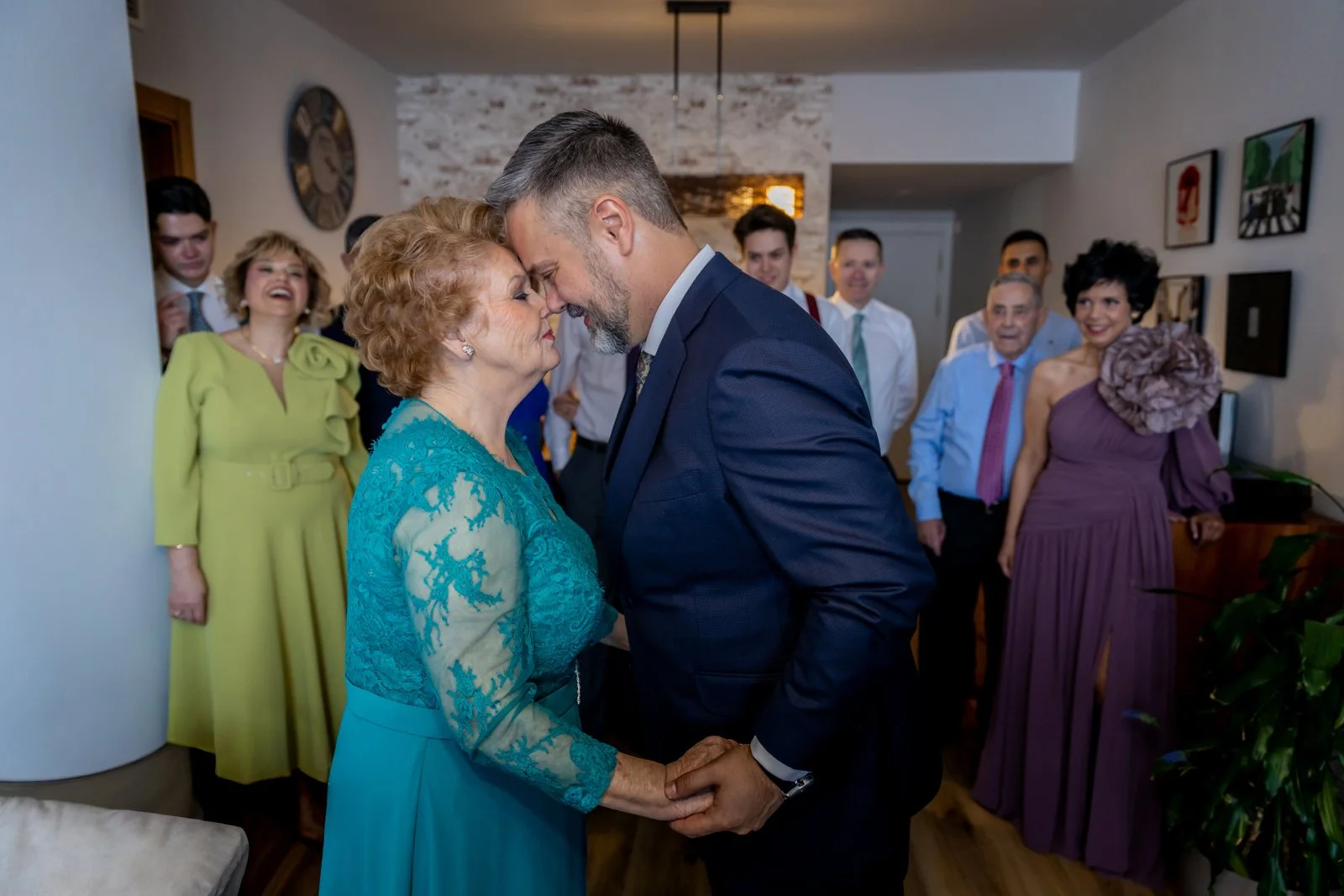 Novio saludando con cariño a su madre ante la familia en una boda en Peñarrubia de Araceli, fotografía de Pedro Zamorano.