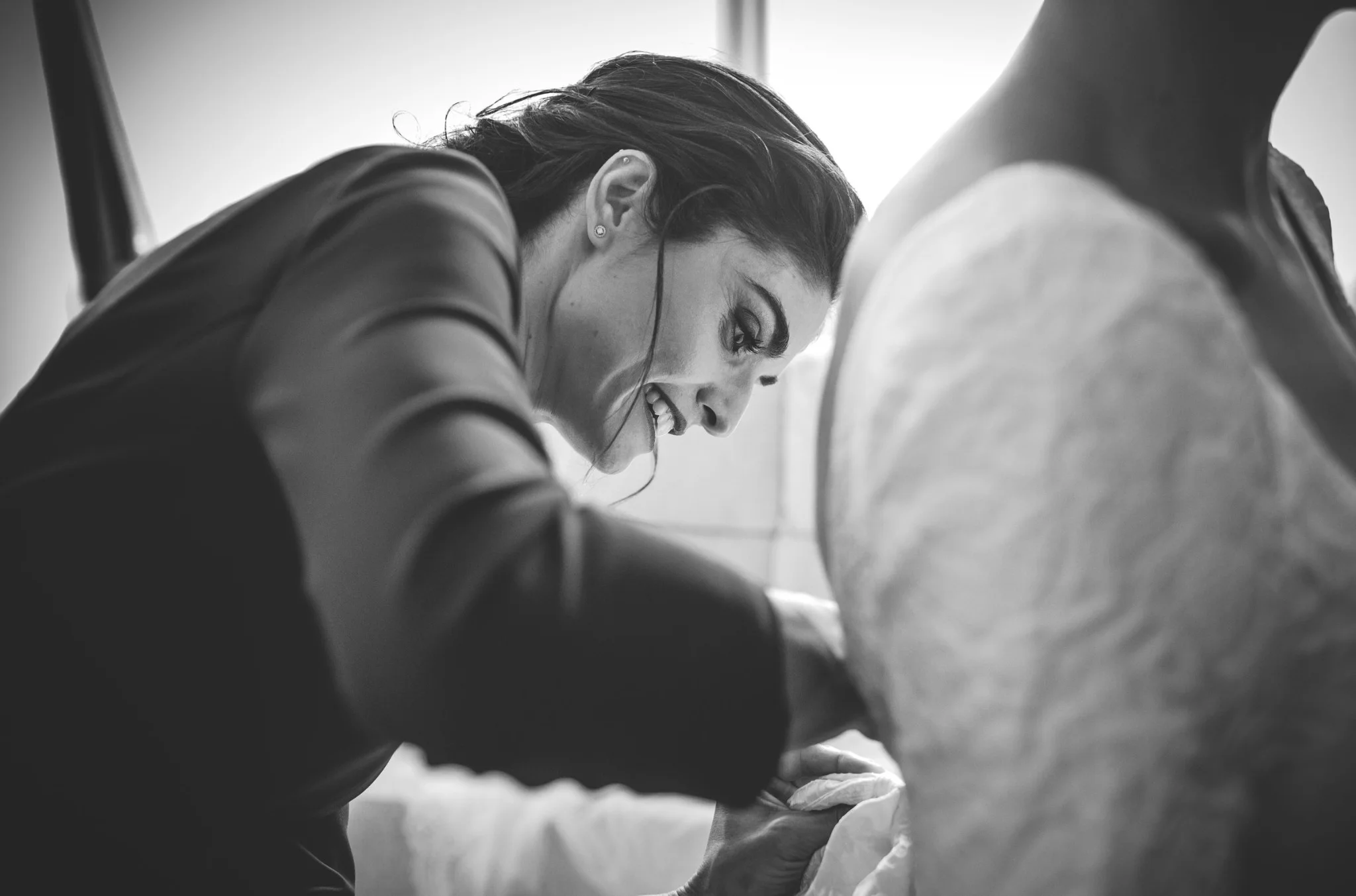Ajuste del vestido de novia en blanco y negro en una boda en Peñarrubia de Araceli, fotografía de Pedro Zamorano.
