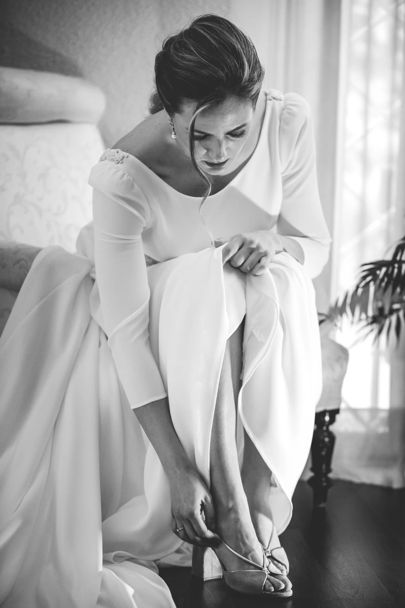 Novia poniéndose los zapatos en blanco y negro en una boda en Peñarrubia de Araceli, fotografía de Pedro Zamorano.