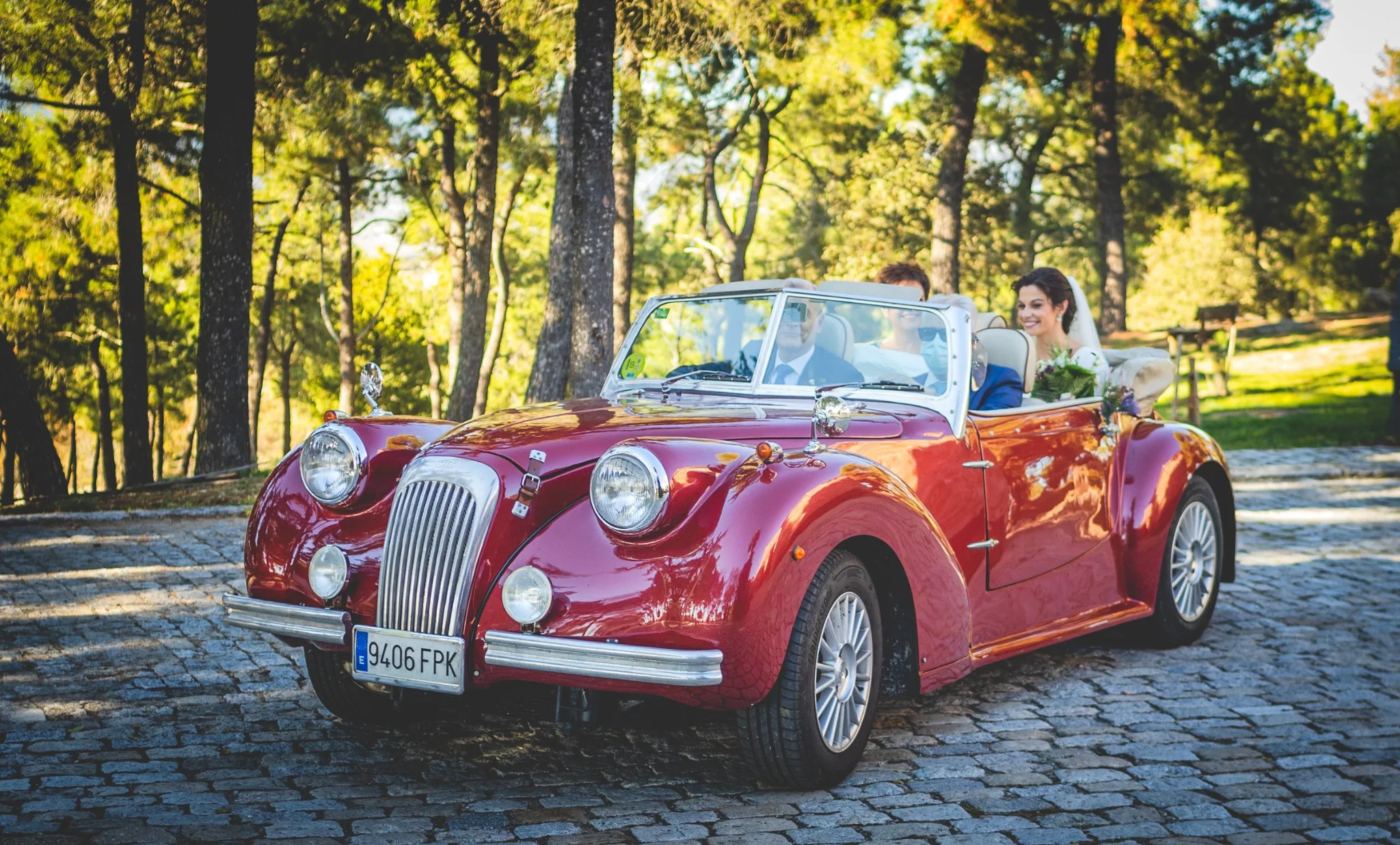 Novia llegando en un coche clásico rojo descapotable en una boda en Peñarrubia de Araceli, fotografía de Pedro Zamorano.