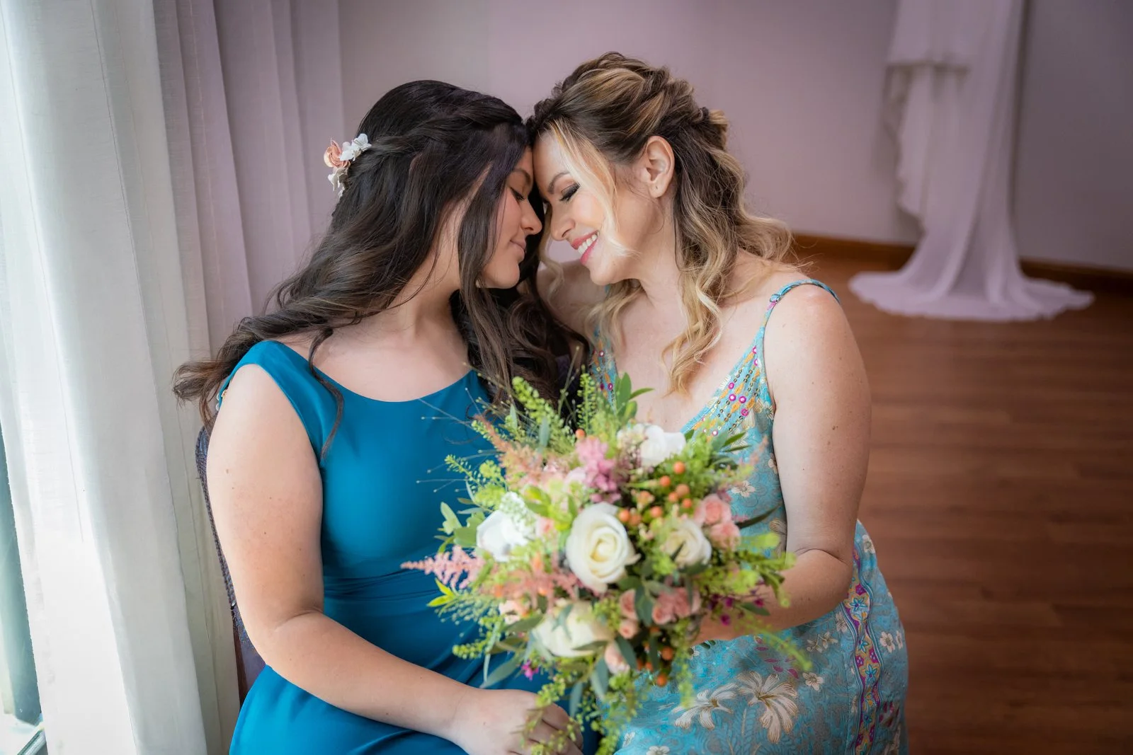 Novia y amiga compartiendo un momento con el ramo en una boda en Peñarrubia de Araceli, fotografía de Pedro Zamorano.