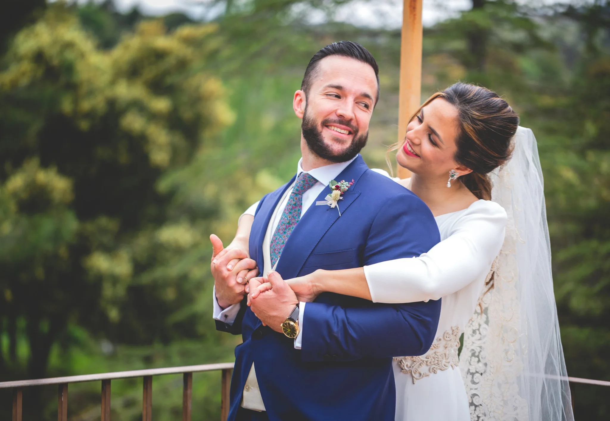 Novia abrazando al novio en los jardines en una boda en Peñarrubia de Araceli, fotografía de Pedro Zamorano.