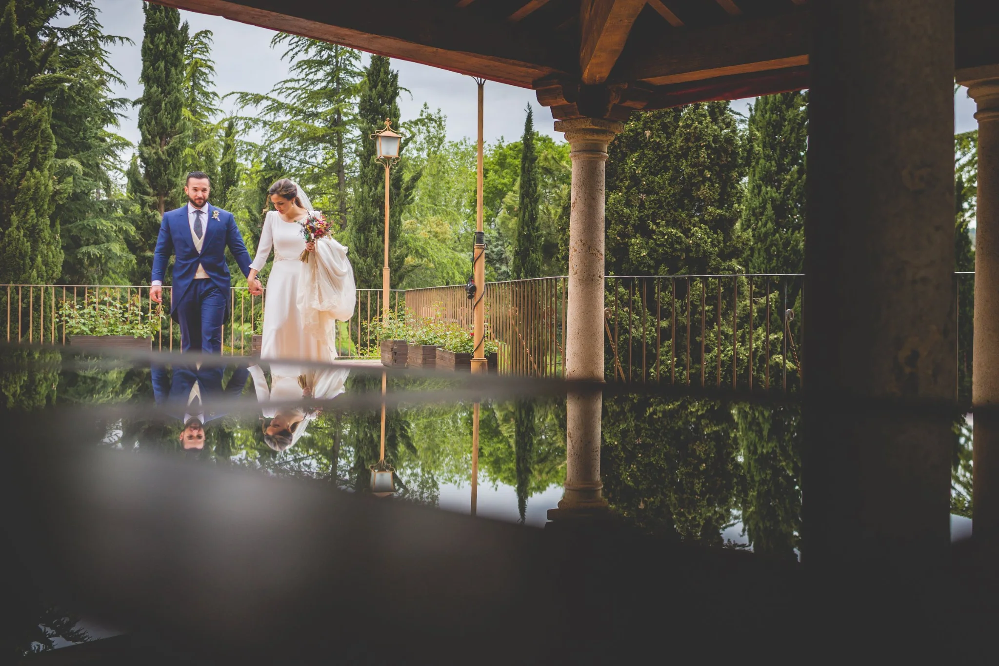 Novios retratados con reflejo en una mesa del porche en una boda en Peñarrubia de Araceli, fotografía de Pedro Zamorano.