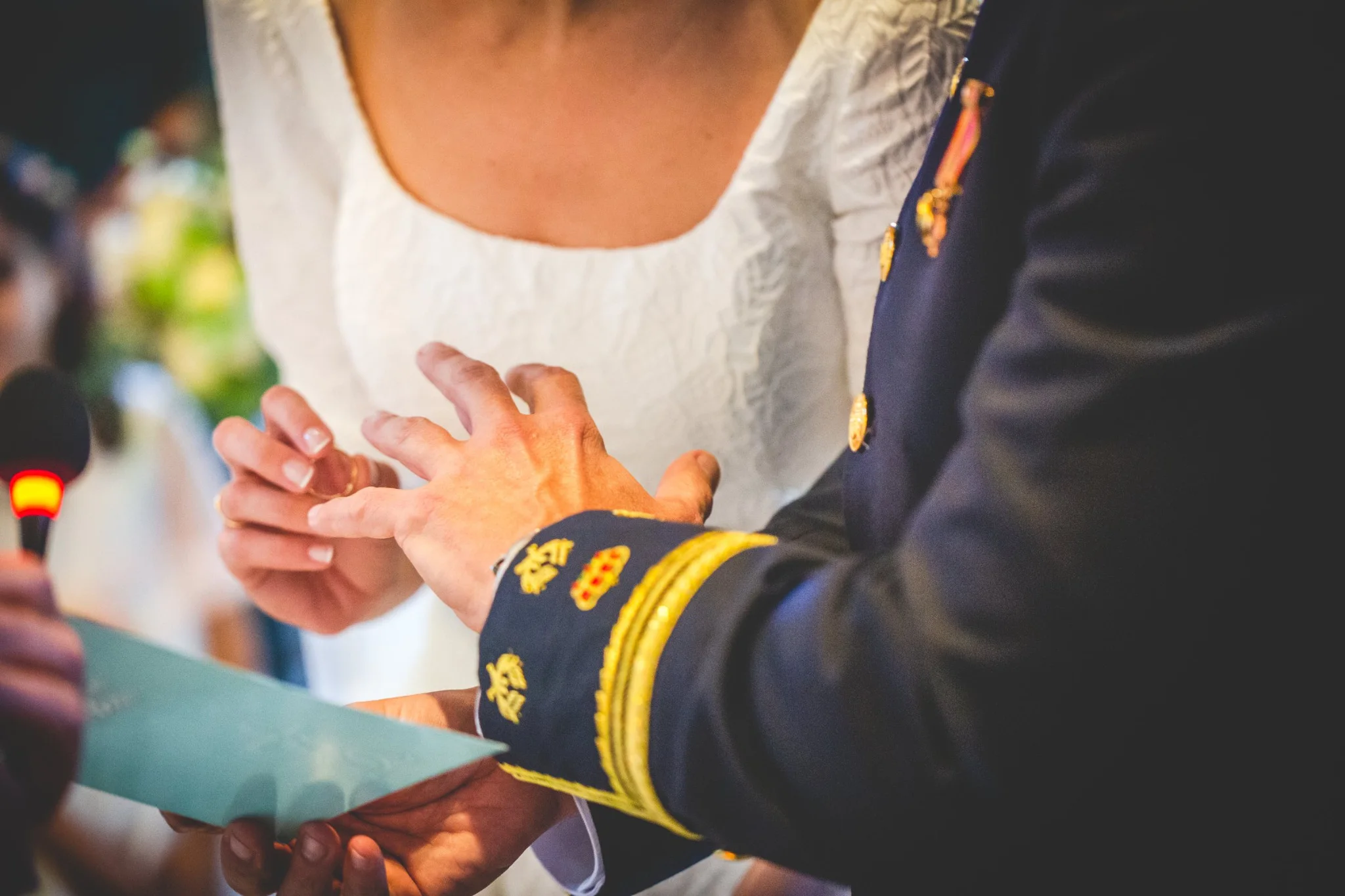 Detalle del intercambio de anillos con uniforme militar en una boda en Peñarrubia de Araceli, fotografía de Pedro Zamorano.