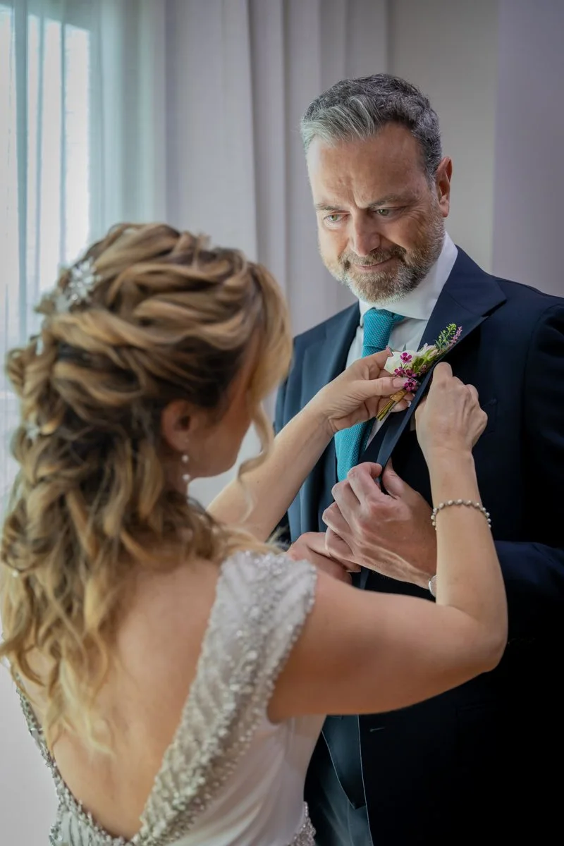 Novia colocando el prendido a su padre en una boda en Peñarrubia de Araceli, fotografía de Pedro Zamorano.