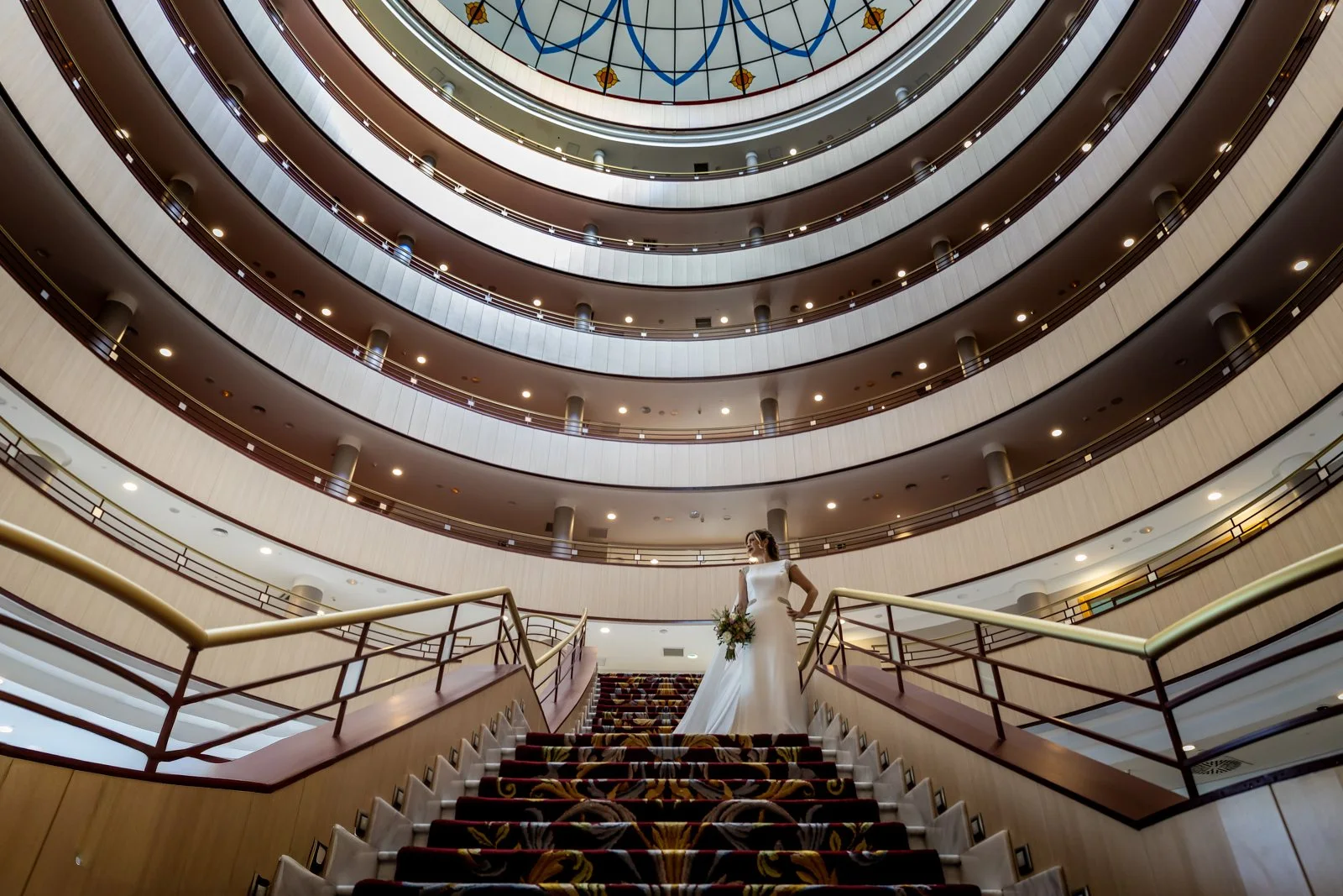 Novia posando en una gran escalera interior en una boda en Peñarrubia de Araceli, fotografía de Pedro Zamorano.